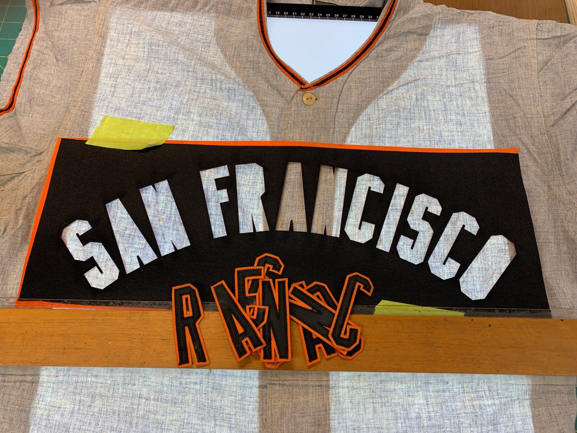 After removing the SPRINGFIELD lettering from the front, the light table helped by showing the ghosts of the original arch and letter placement. The new lettering was pre-stitched then was media blasted and dyed to give it the patina of age to match 