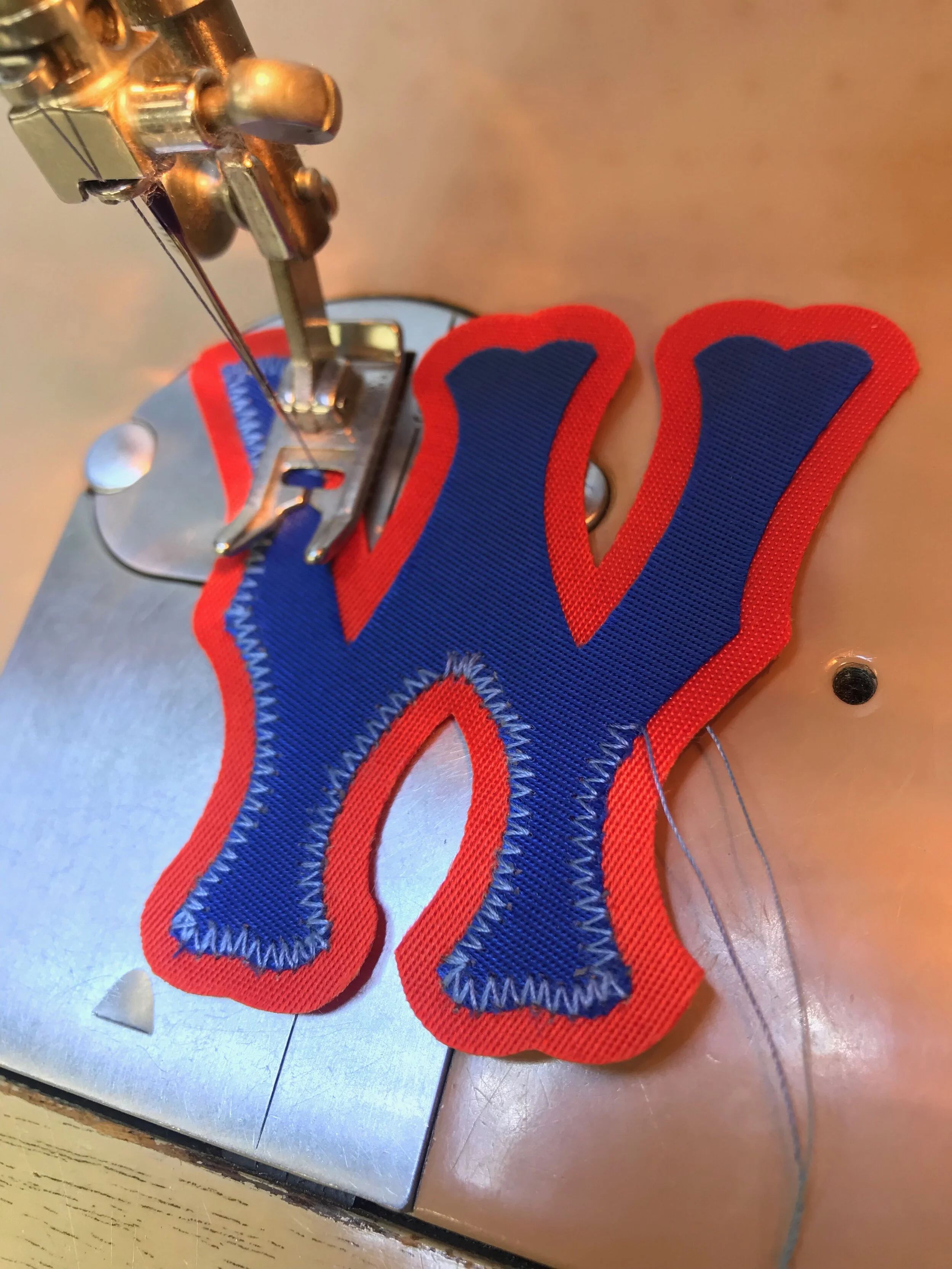 To match the bleached thread that secures the adjacent player numbers, I use new thread that color-matches the original. This bleached-blue thread is from my grandmother's thread box and is probably sixty years old.