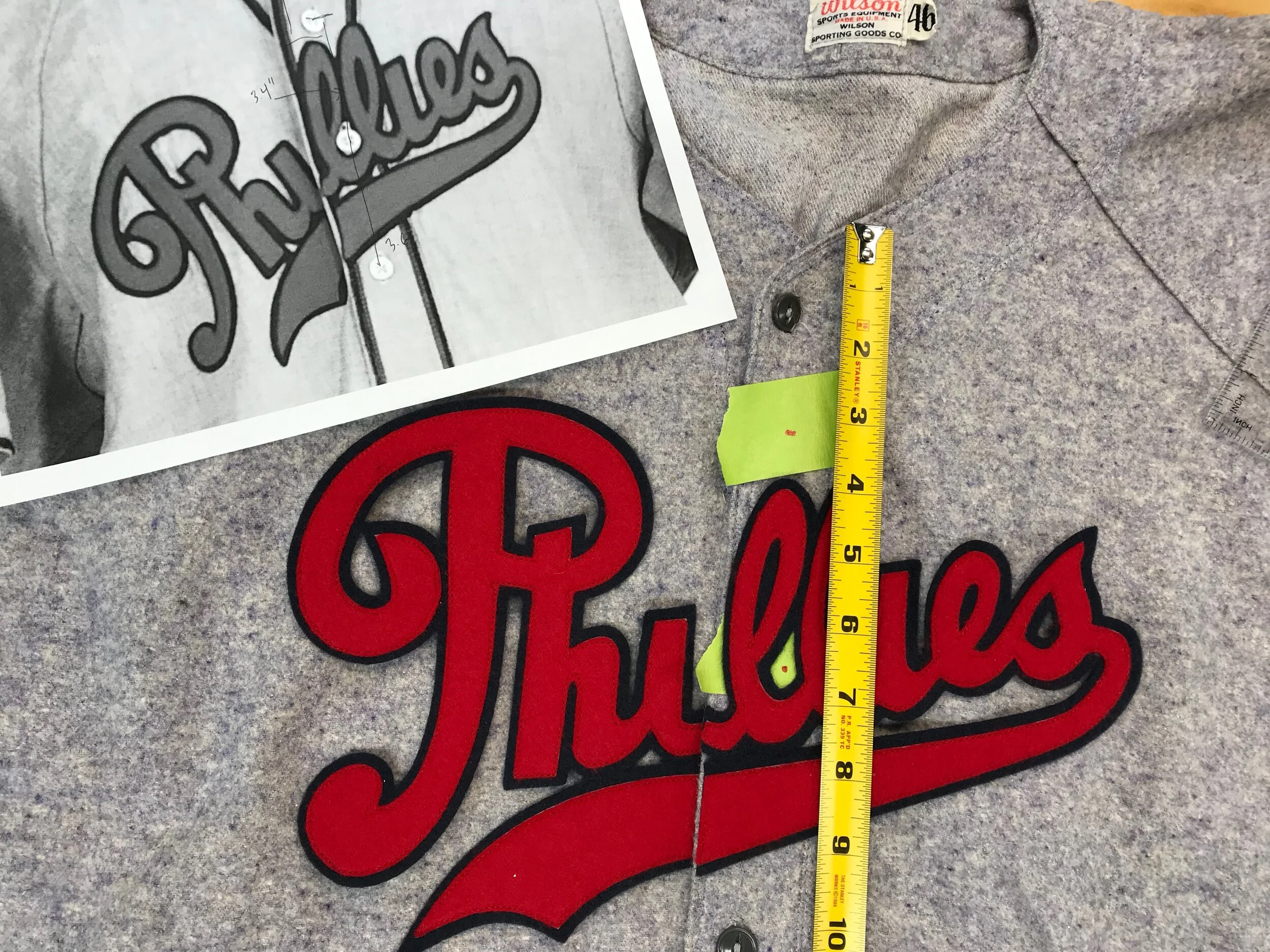 Now, we'll move the two misplaced buttons and buttonholes. I've clearly noted the proper measurements on my drawing, then temporarily placed the front wordmark where it belongs. I've marked the locations for the repositioned buttons using painters' t