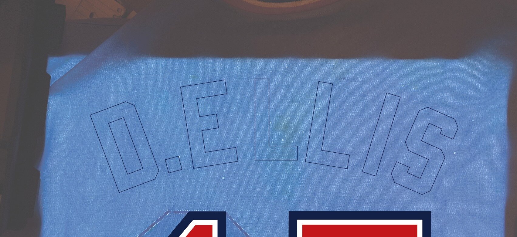 But I was stumped. I used my scanned image of the back of the jersey and tried to make “D. Ellis” fit in the standard font, the one used for the long name “BABCOCK” covering the scant shadows I could see of the name that had been there before. And tr
