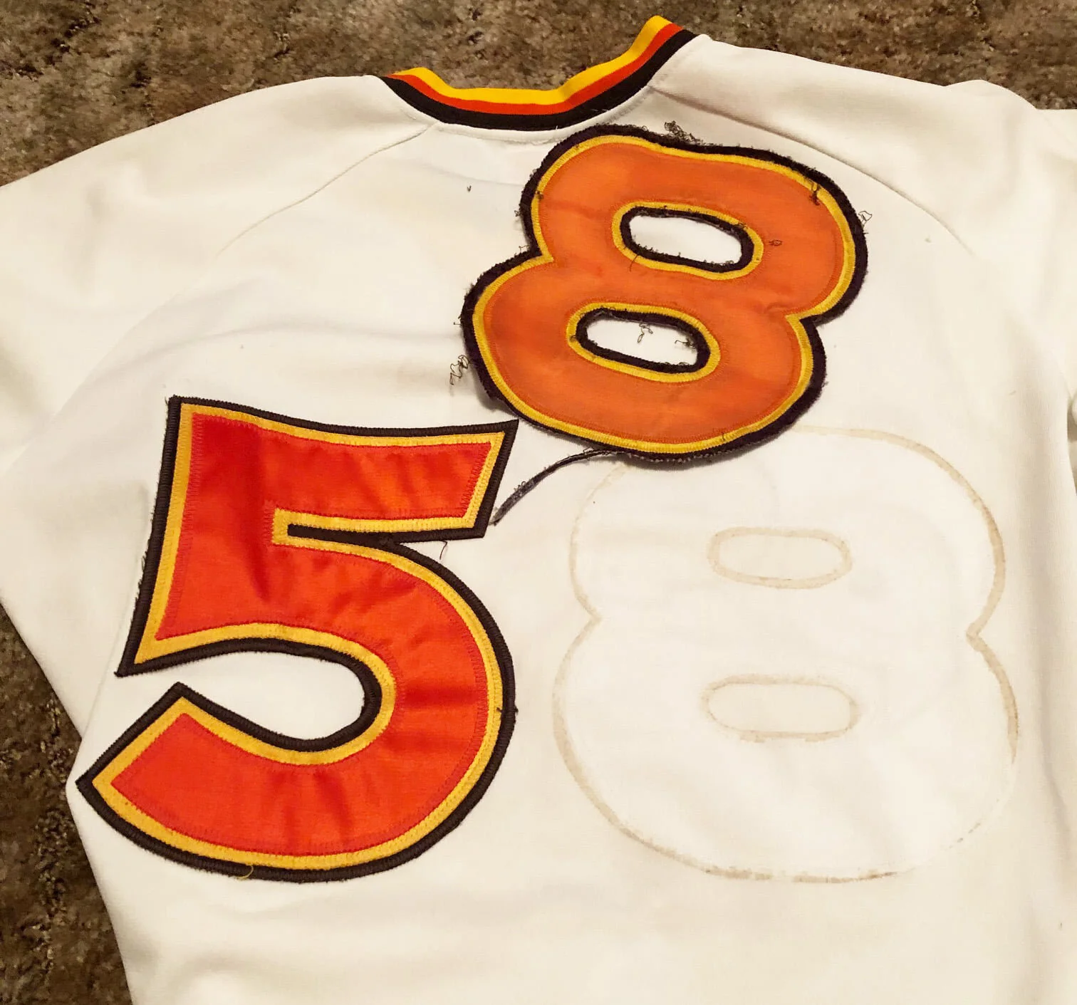 The Wilson tagging was correct and it showed evidence of with multiple player name and number changes. The first thing I did was to remove the mis-sized crazy looking “8” on the back, and put the jersey on the light table. On the back, there was evid