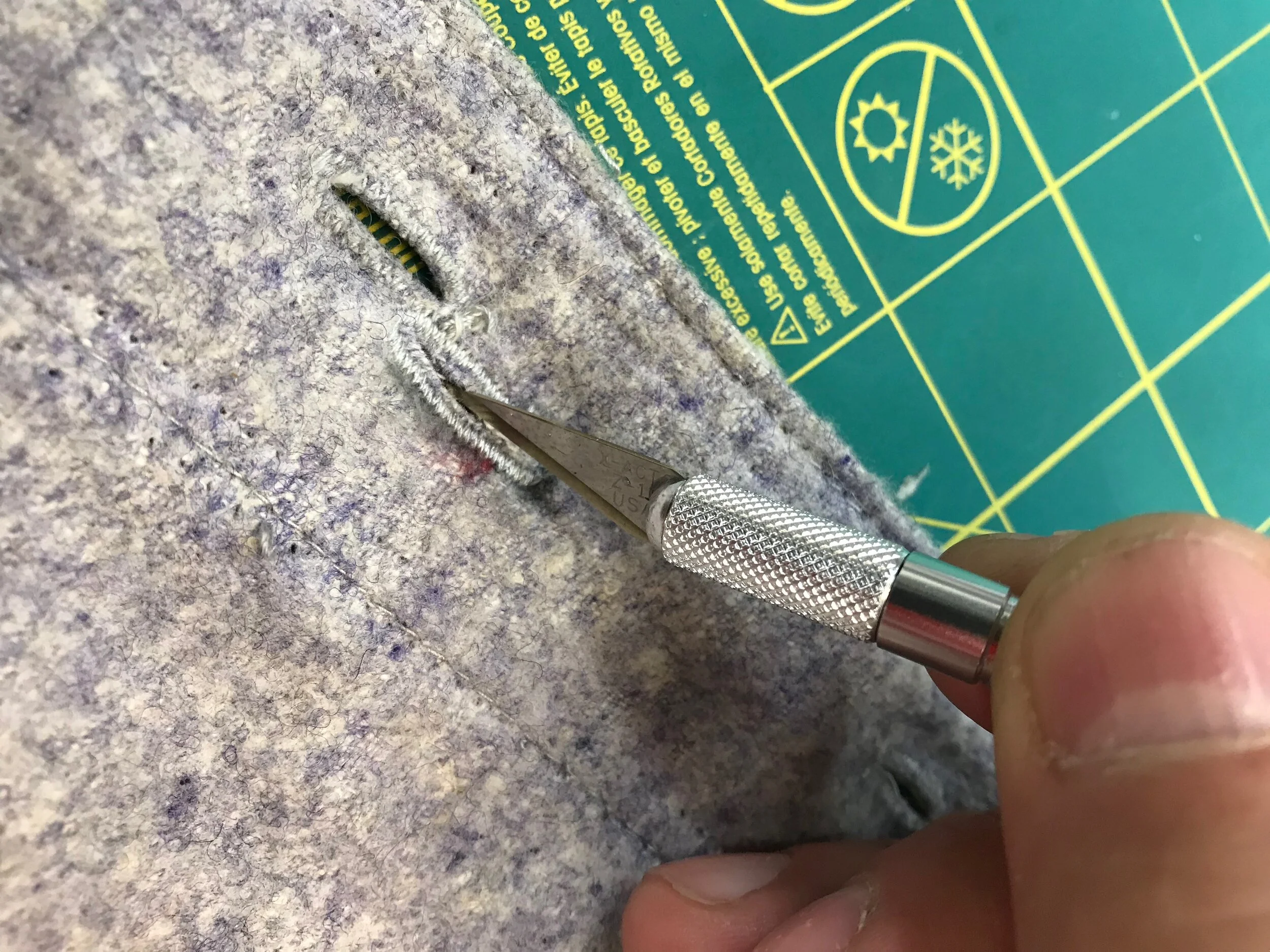 Once the buttonhole outline is sewn, I cut a slot to open it with a small, sharp knife.