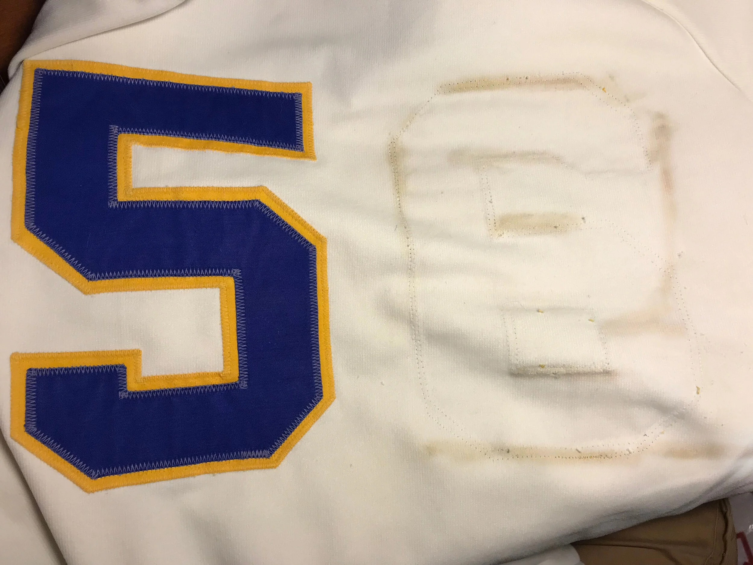 When removed, the back number left glue and dirt stains showing the original number "2" outline.