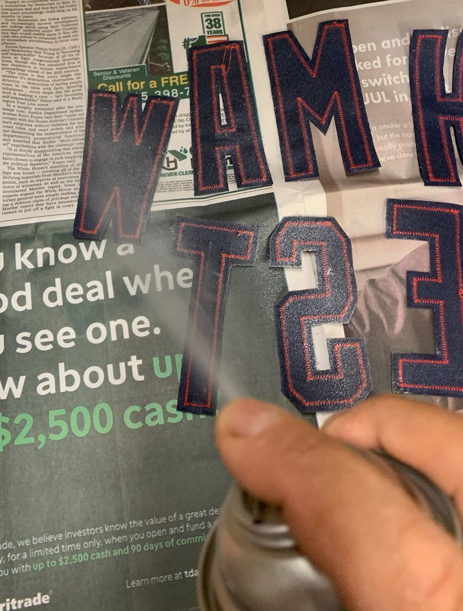 I lightly spray the backs of the letters with a tacking adhesive so they will stay put for stitching once I have laid them in place.