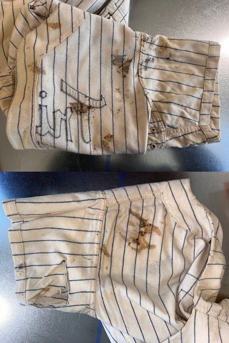 Looking at it more closely, we turn it inside out and find that it is absolutely filthy. It looks like coffee grounds and cat poop have been rubbed into it. There's a large L shape rip in the back of one of the sleeves. Looking at it, there's no sign