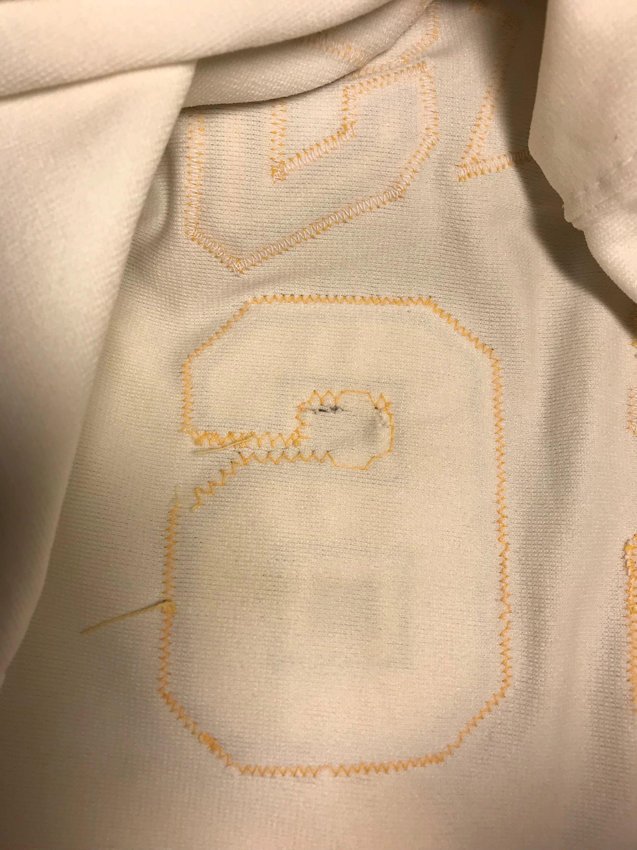 From the back, we can see that they didn't even bother to completely stitch the number on, leaving the center unattached. We can also see a hole where the "2" was removed.