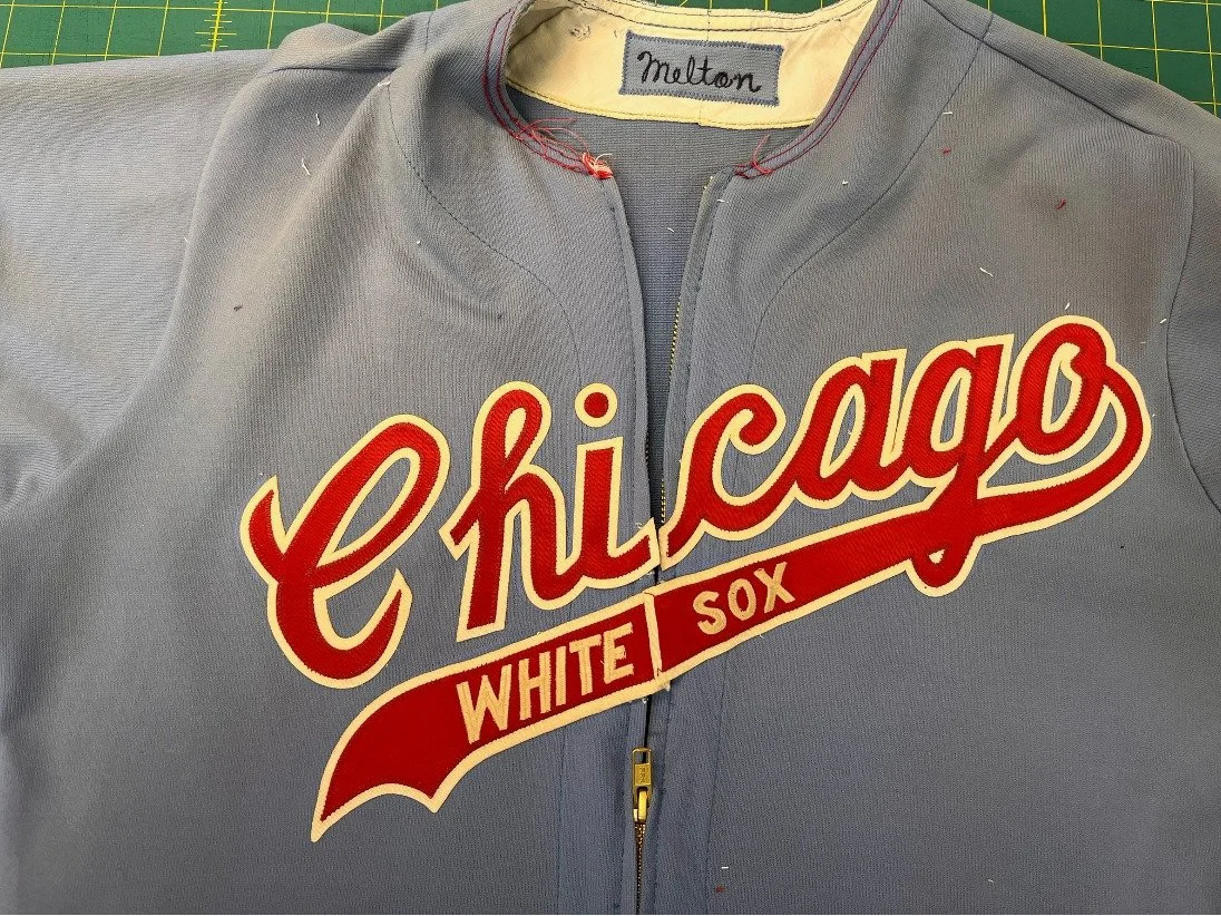 After cutting the lettering, I test-place it on the garment to see if it covers the shadows. The small ”WHITE SOX” lettering on the tail of the logo was hand embroidered by seamstress Emily, who also sewed in the new zipper, the new trim and all the 