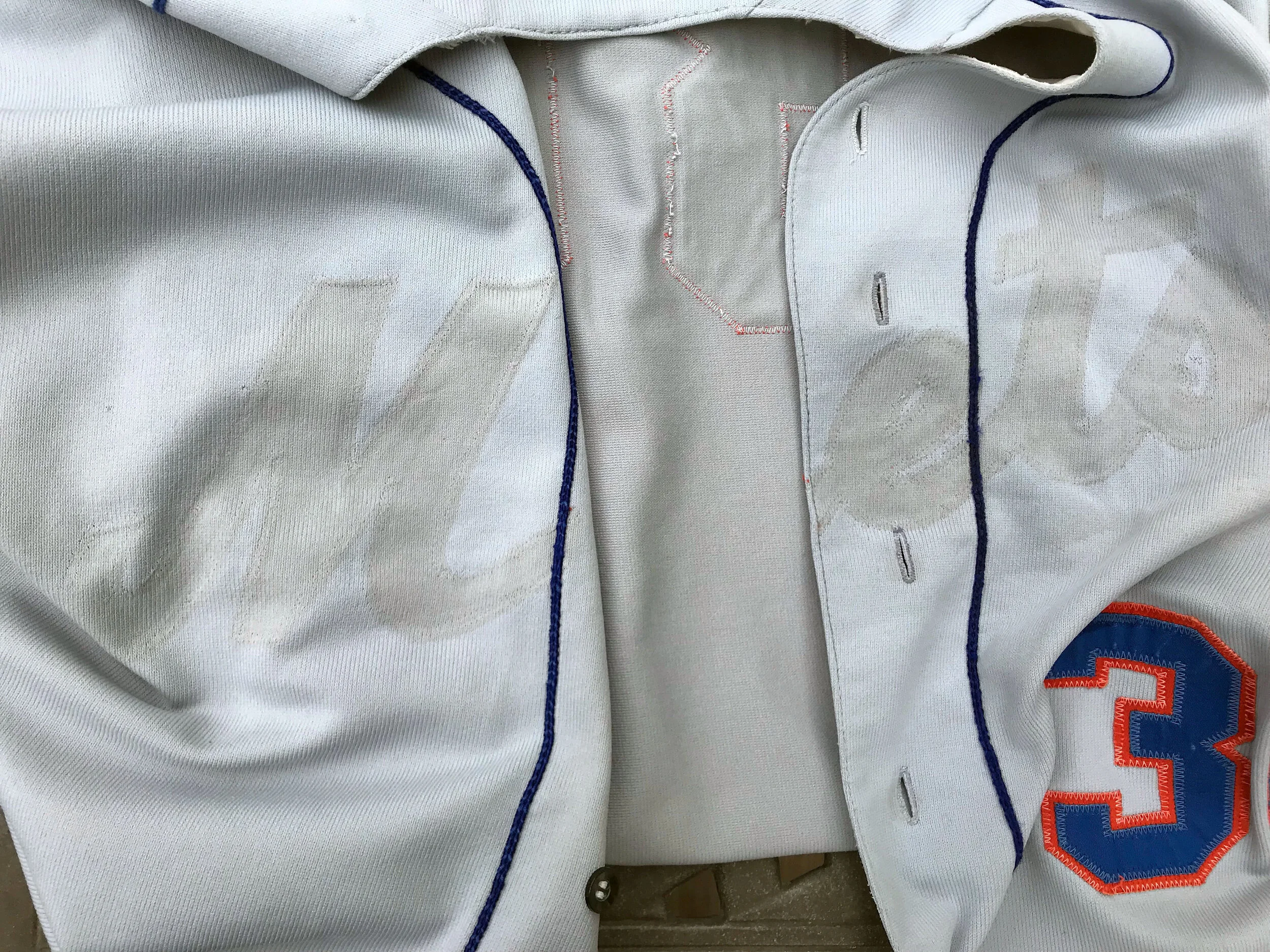 With all of the lettering removed, we have an issue: the ghosts of the old lettering are quite visible. Note that this is not a stain; rather all of the rest of the fabric has faded from use in the bright sunlight over many years. Look carefully, and