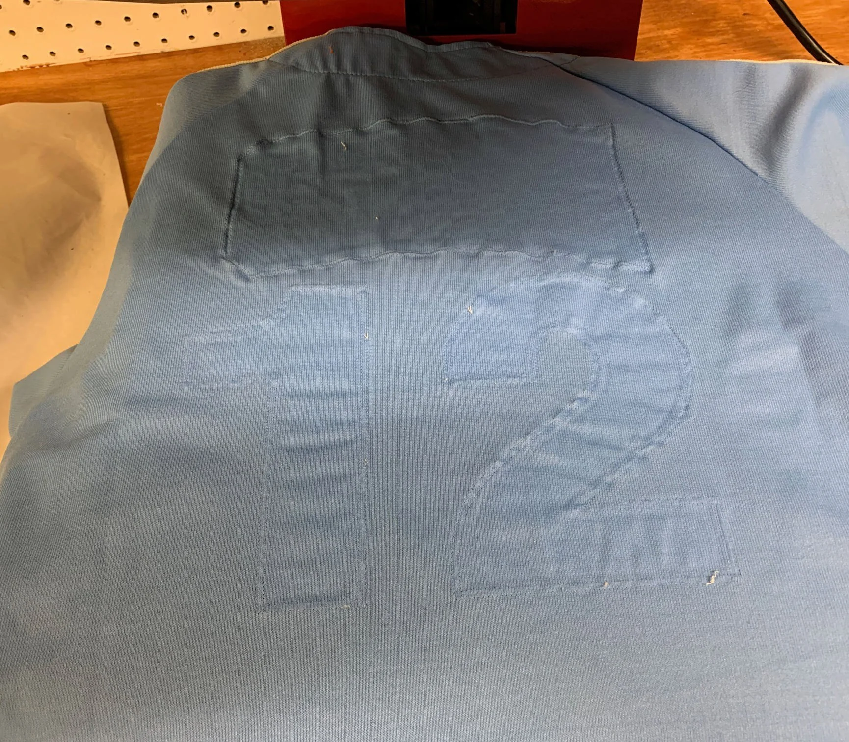 BEFORE- this jersey is clean. Never steam a dirty garment. The puckering beneath the old lettering is caused by the two types of fabric shrinking at different rates after dozens (hundreds?) of washes.