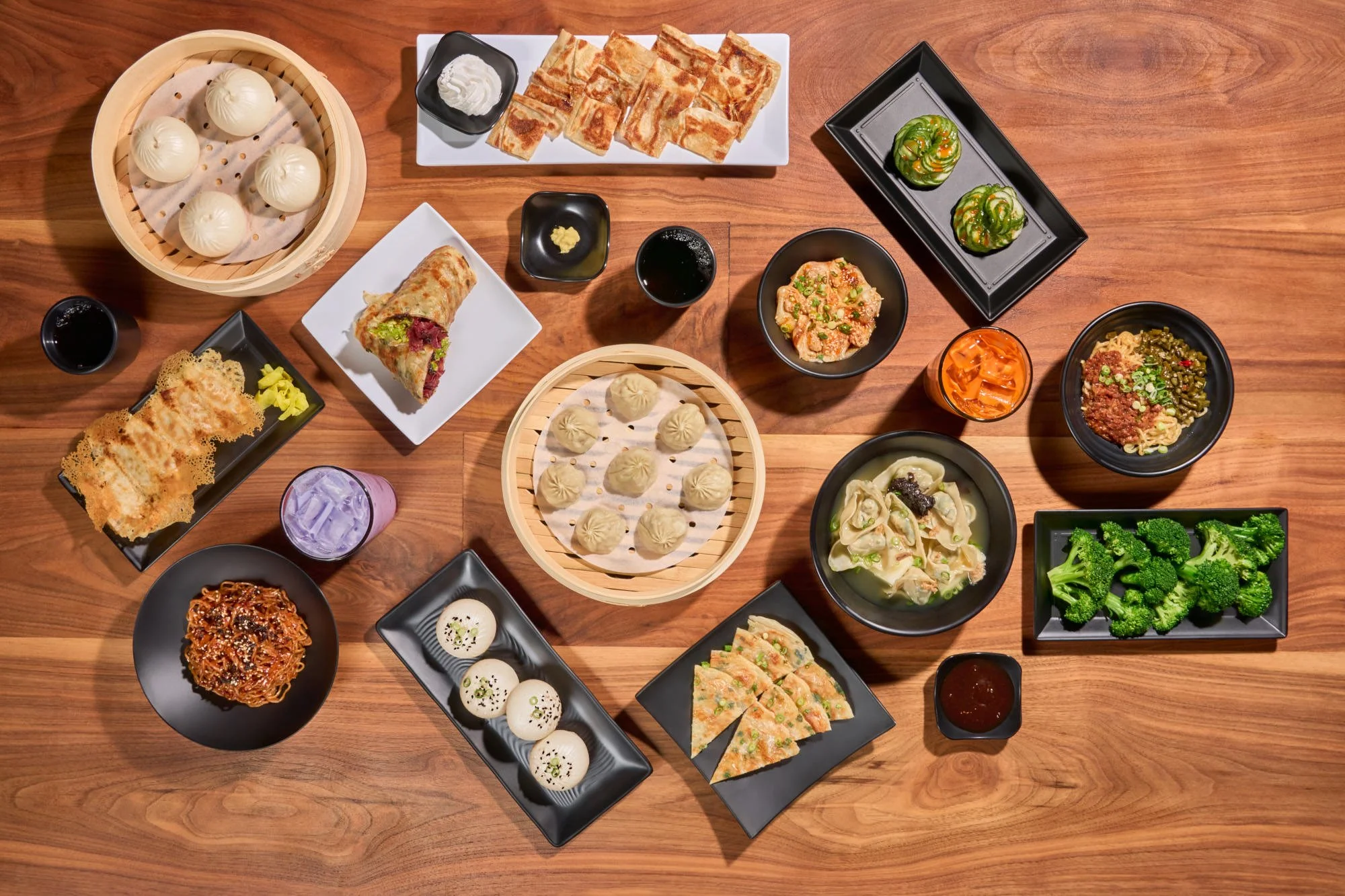 Plated at Dough Zone, Seattle bar and restaurant photography, spread of dumplings, cucumbers, xiao long bao, and other dim sum
