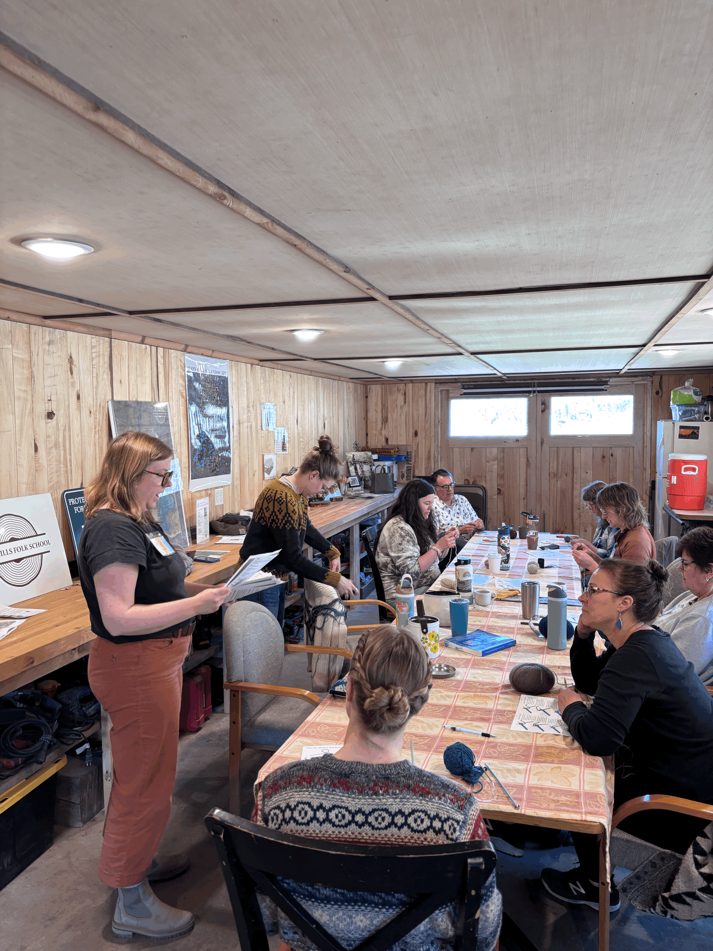 a group of people around a table knitting