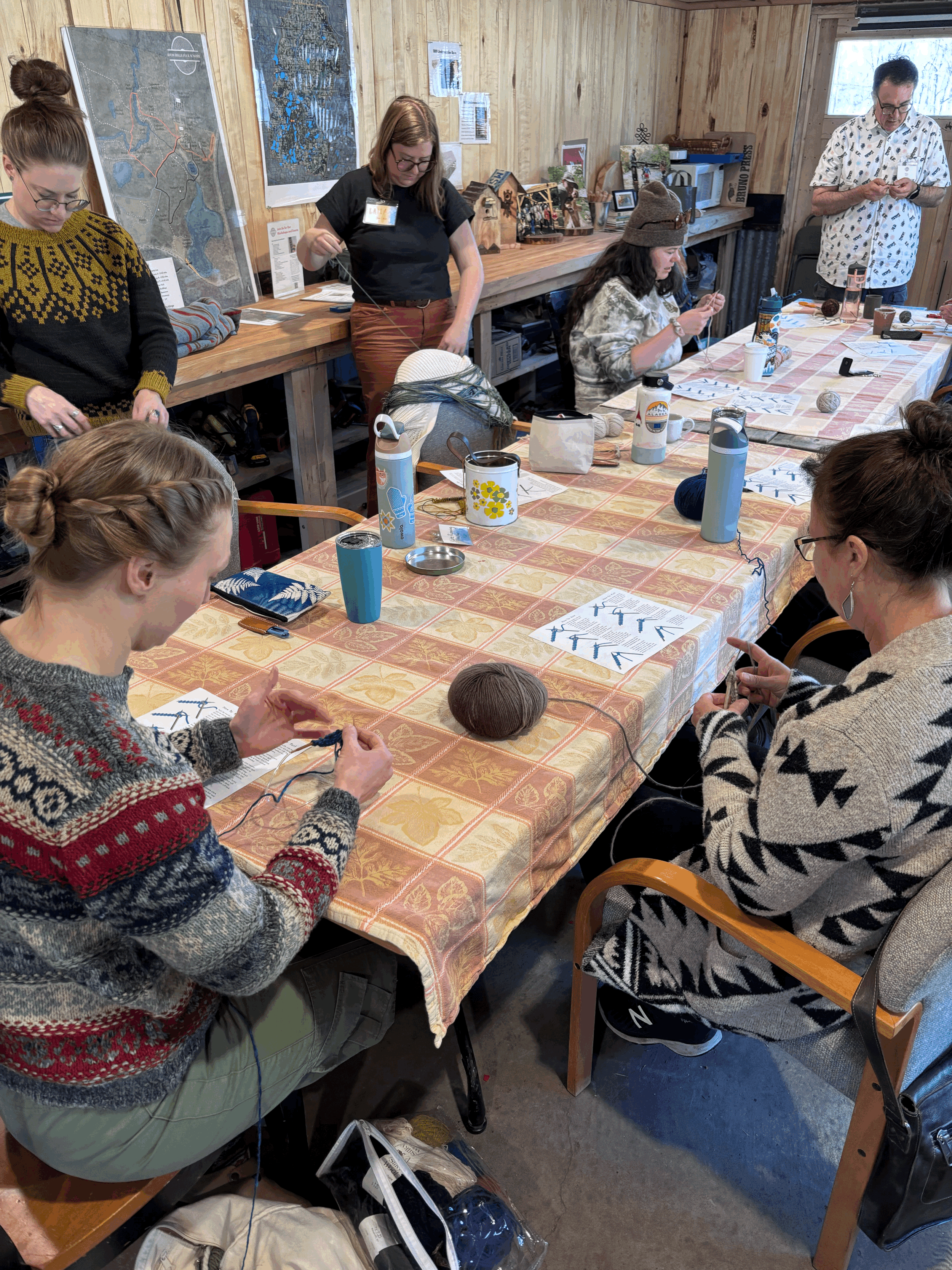 a group of people around a table knitting
