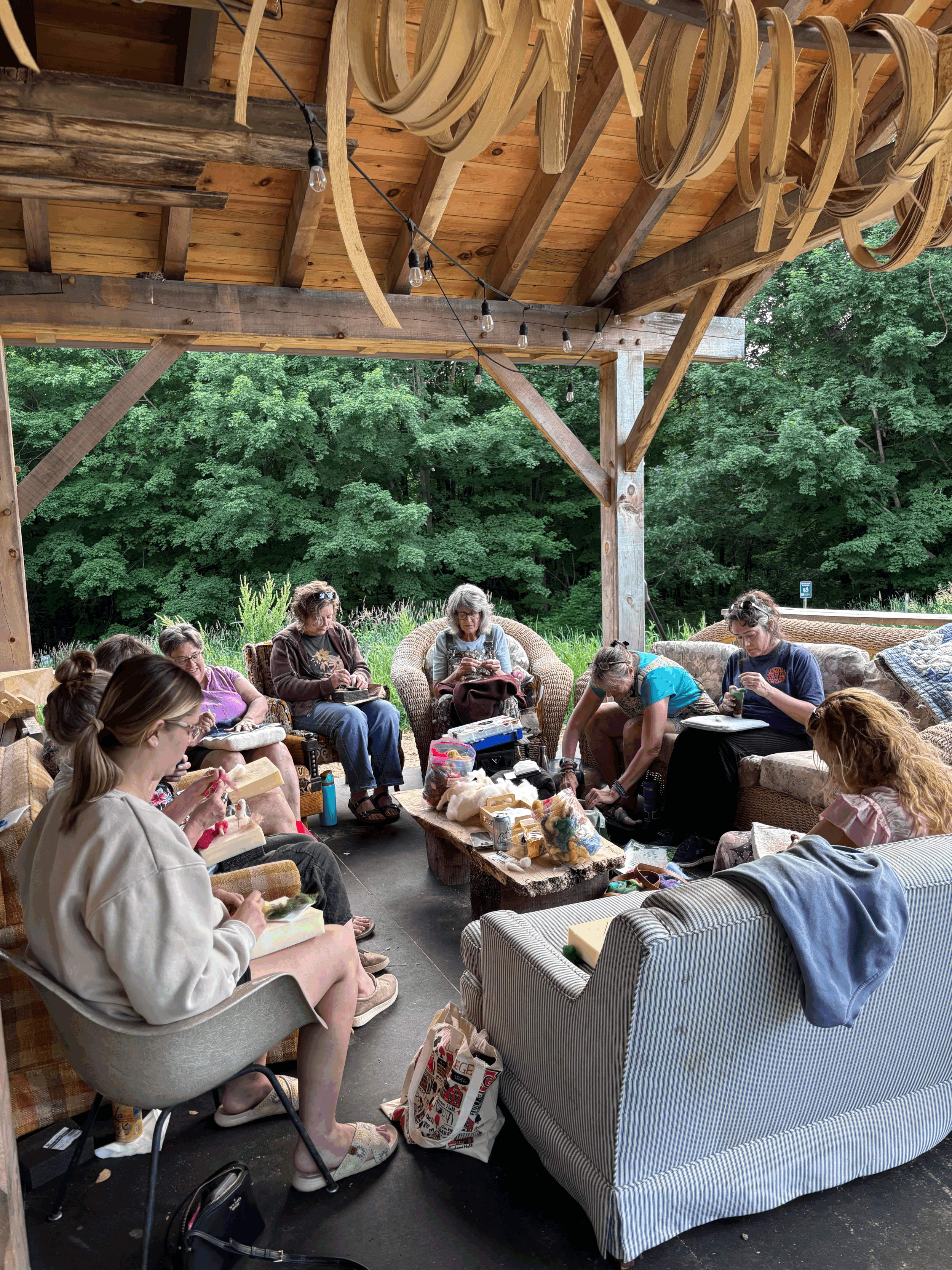 group of people in a gazebo type building doing felting projects together