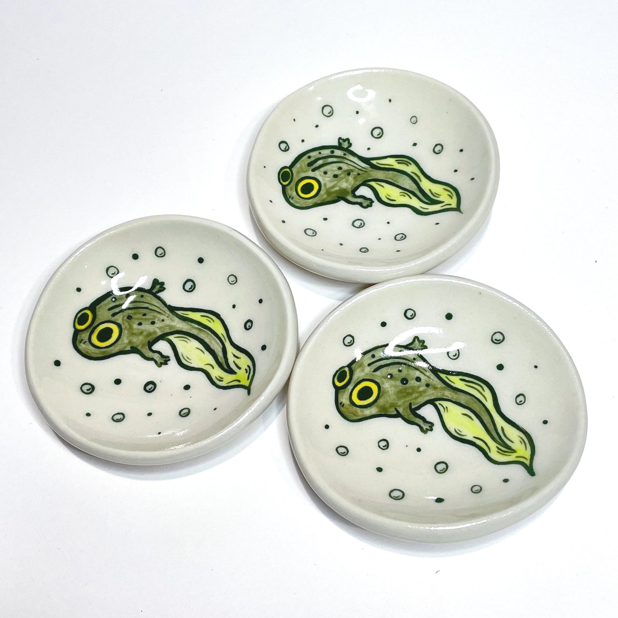 three small trinket dish with a tadpole illustrated on each one.