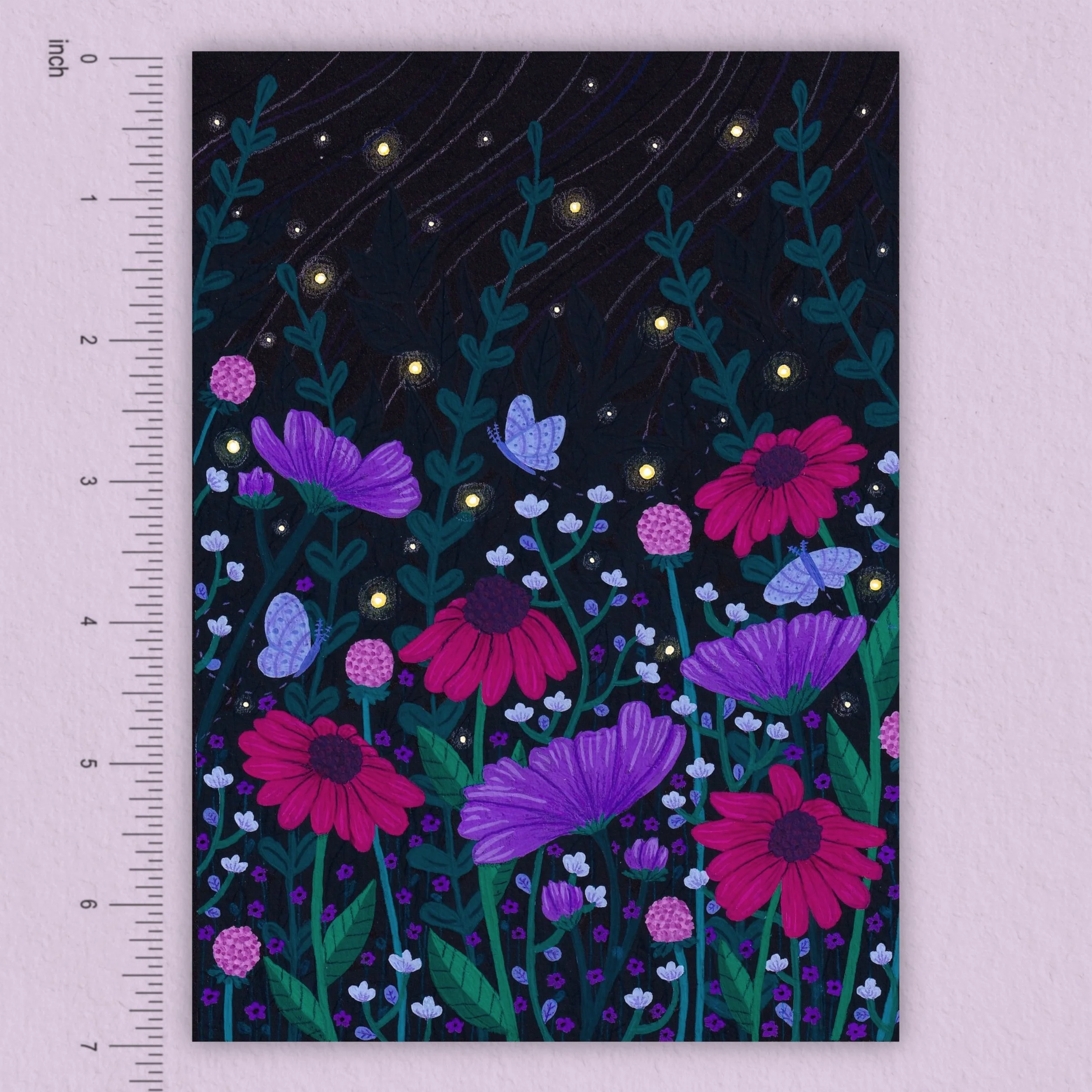 an art print on a pale pink background of a field of pink and purple flowers against a dark starry sky with a ruler to show scale