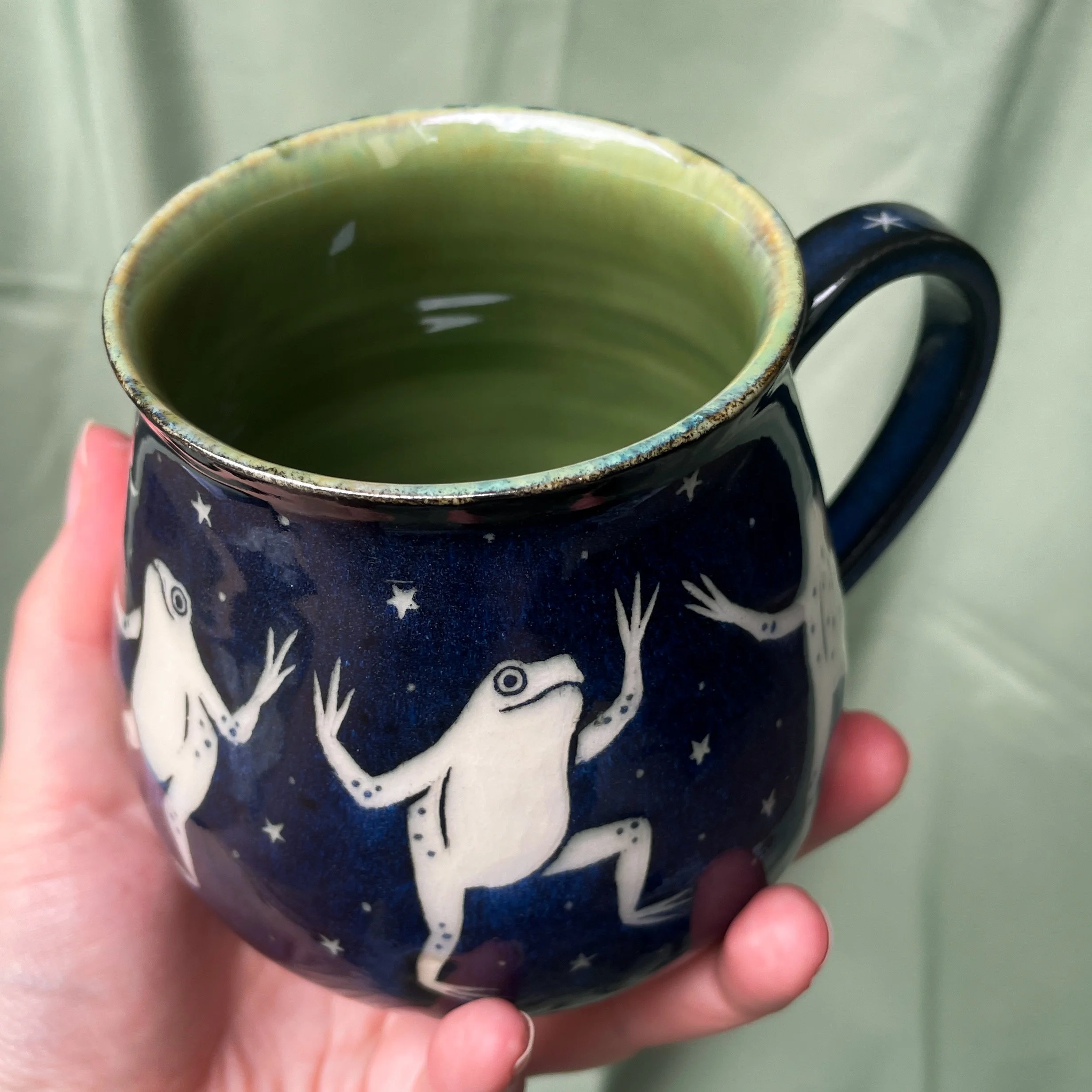 dancing frog cauldron mug a held up.JPEG