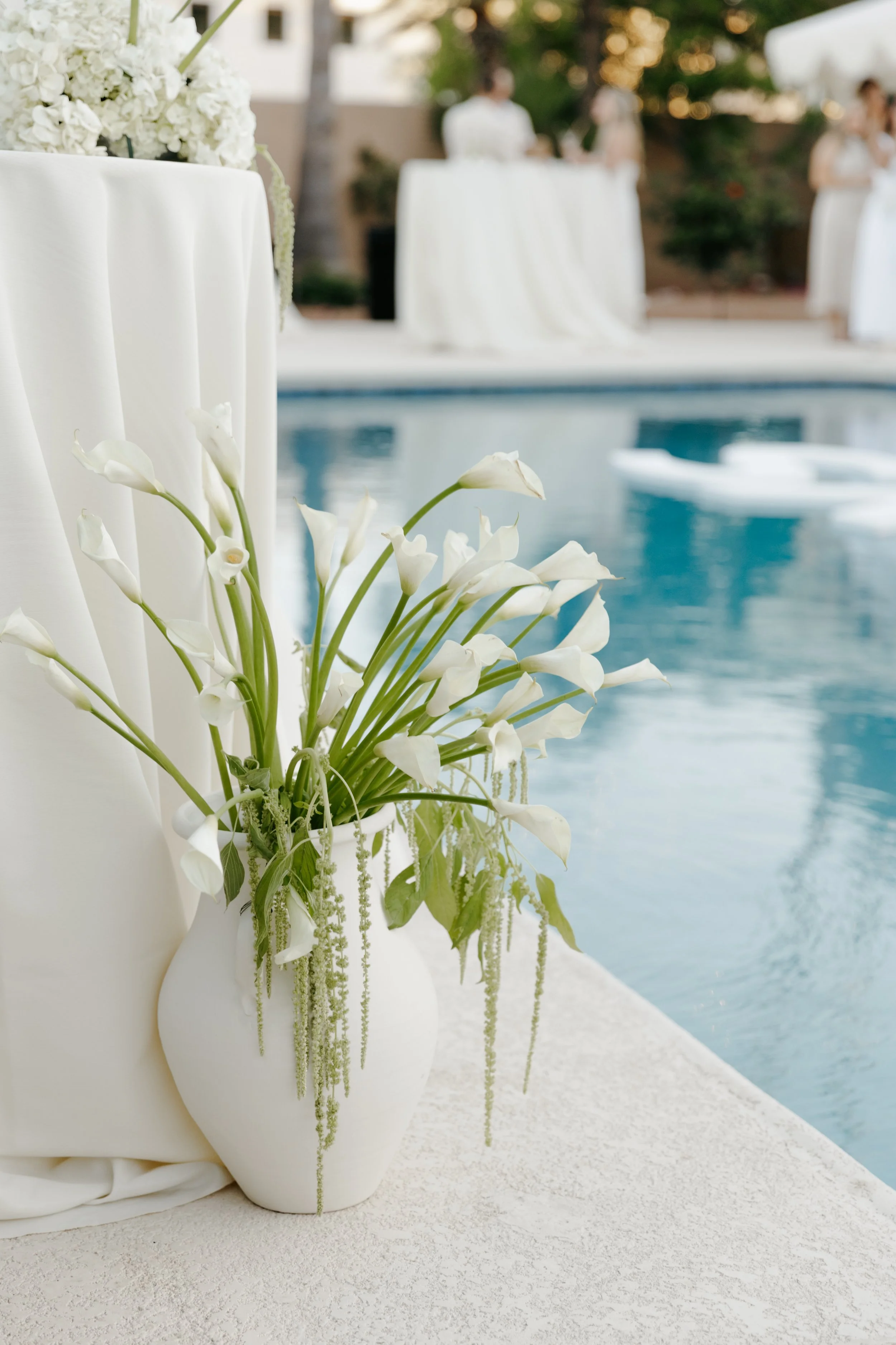 An intentional small wedding reception at a private residence near Camelback Mountain, with white flowers near a turquoise pool. Scottsdale Arizona digital and 35mm film wedding photographer.