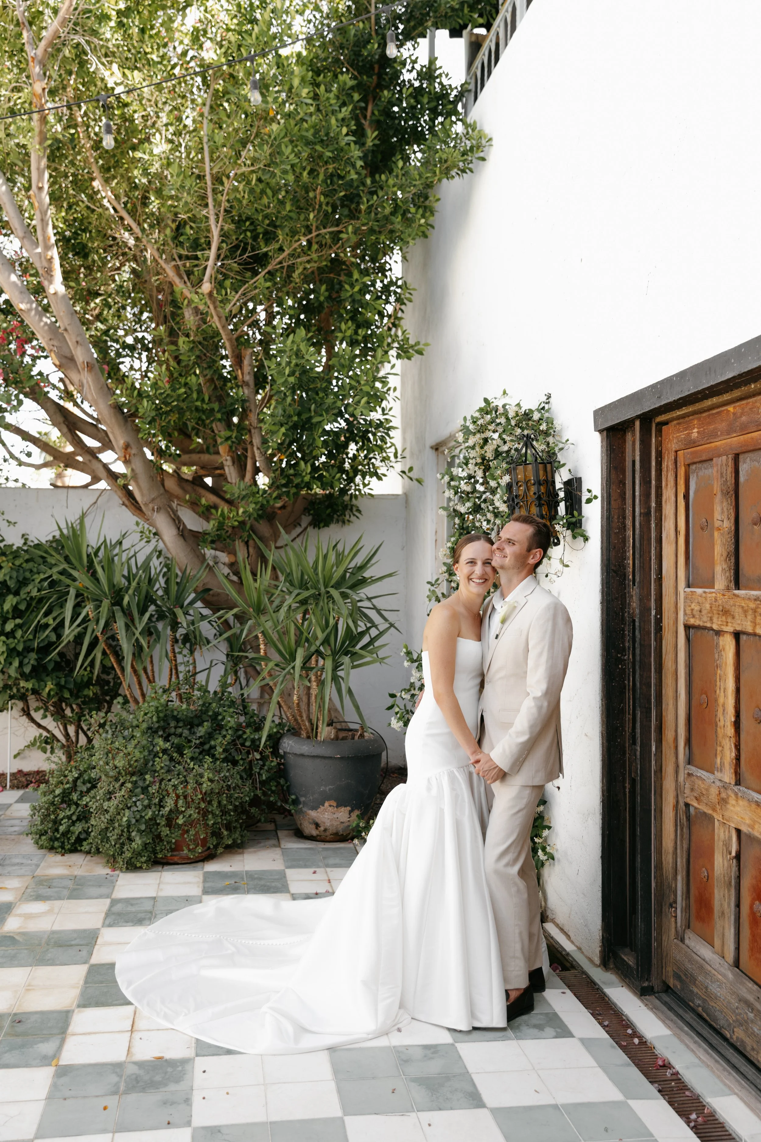 Bride and Groom standing in front of doorway at La Estancia. Arizona 35mm Wedding Photographer.