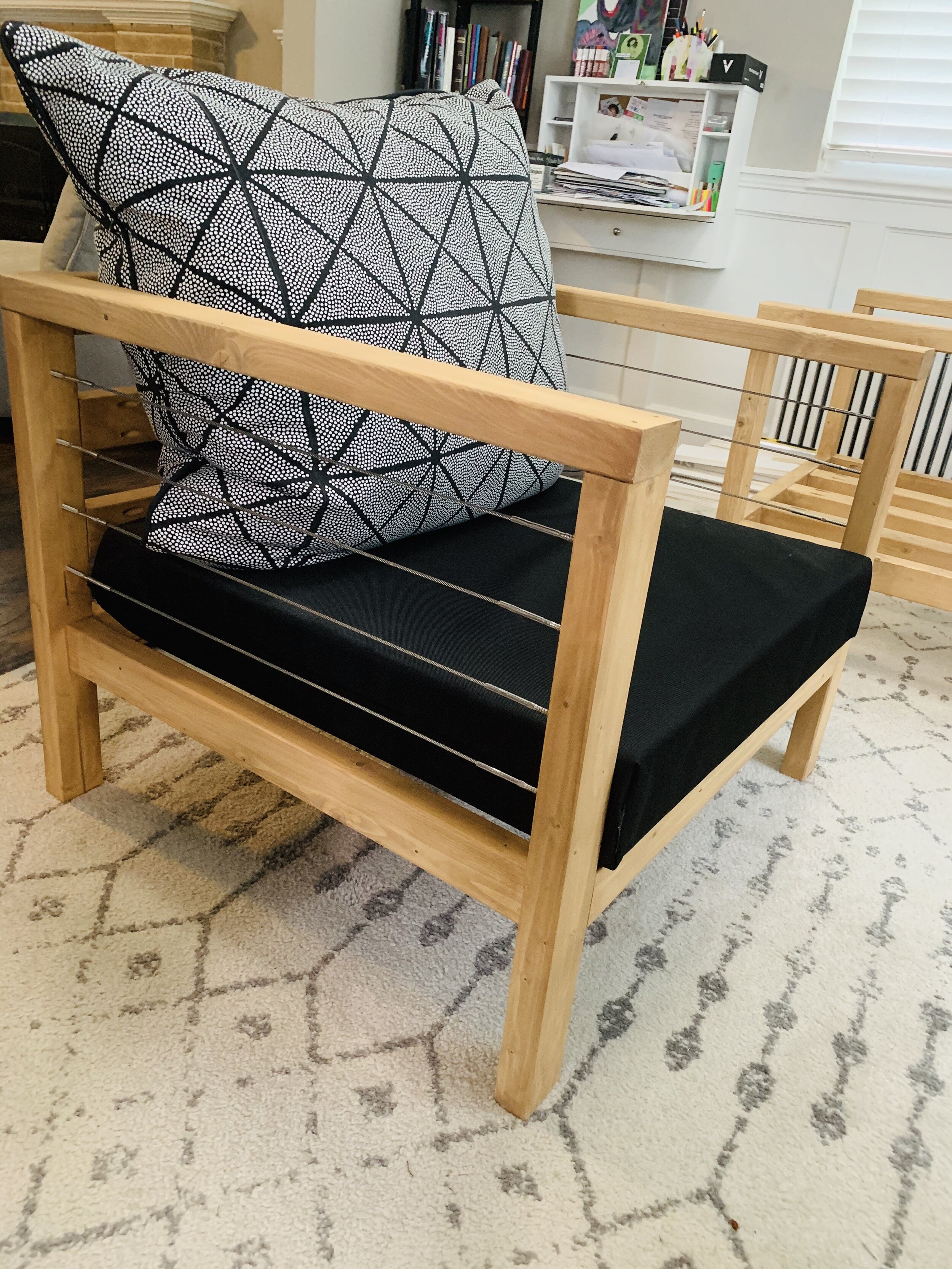 Patio chair with cable railing sides and custom cushions.