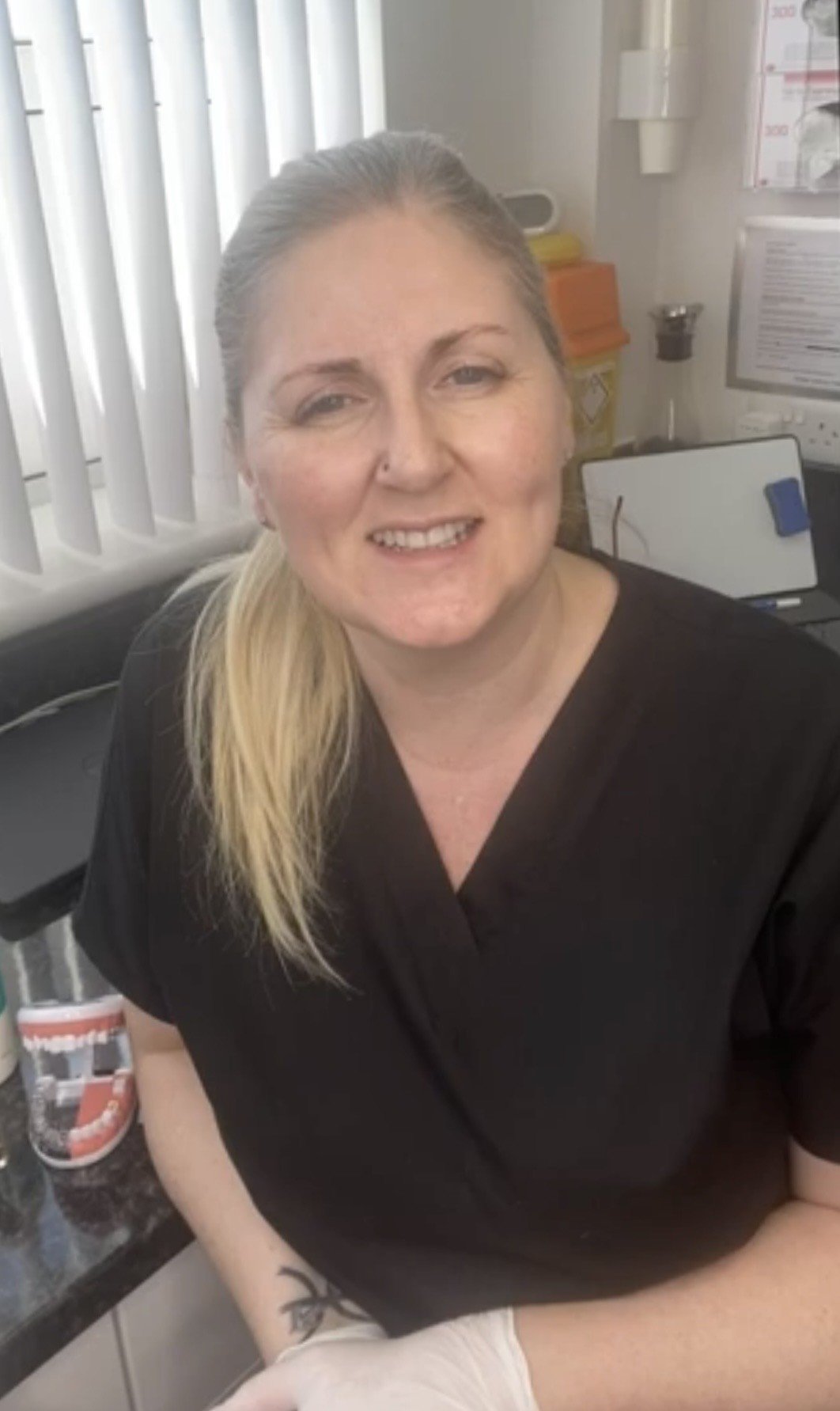 Jacqui sitting in dental room with a mouht model explaining  the ohh flow experience