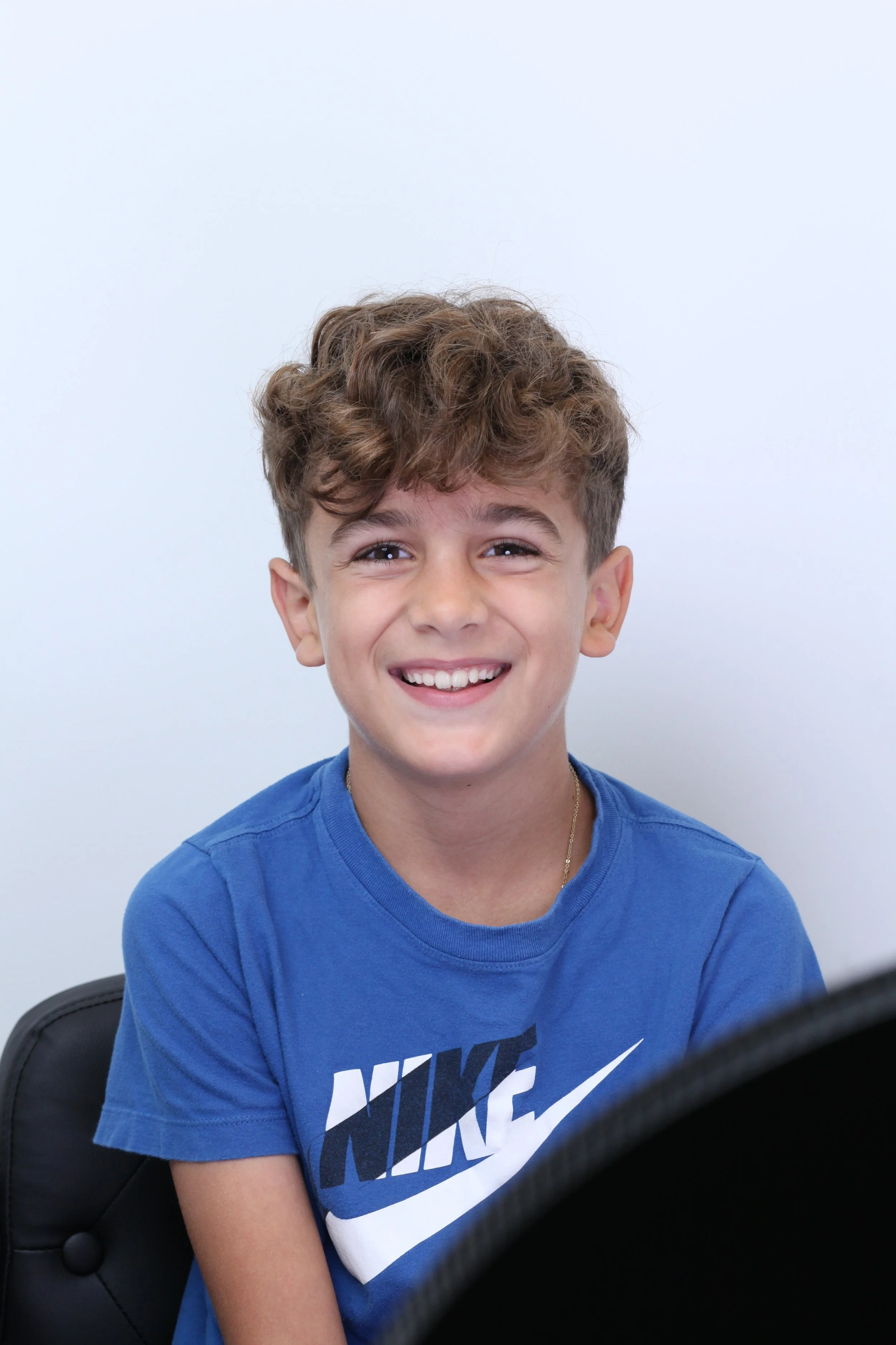 Portrait of a boy smiling in front of a plain background - Overbite vs. Underbite in Westfield, IN