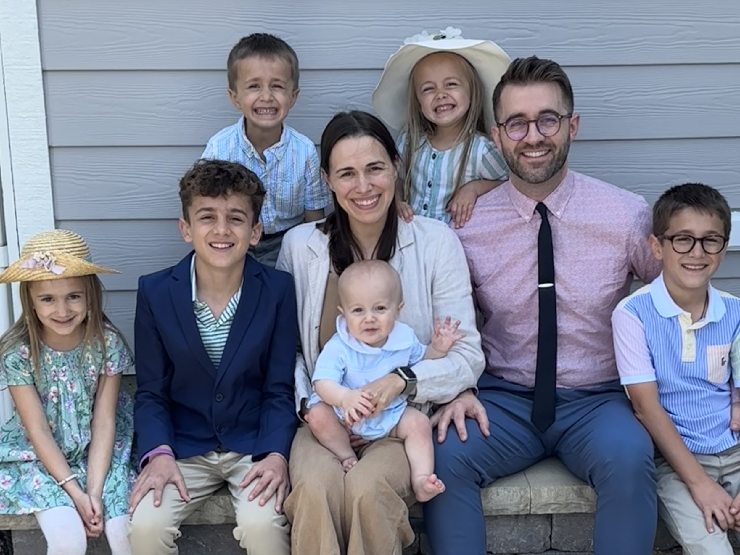 Smiling family of Dr. Titus seated on a porch, showing off healthy teeth after orthodontic care — How Long Do Braces Take in Westfield, IN?