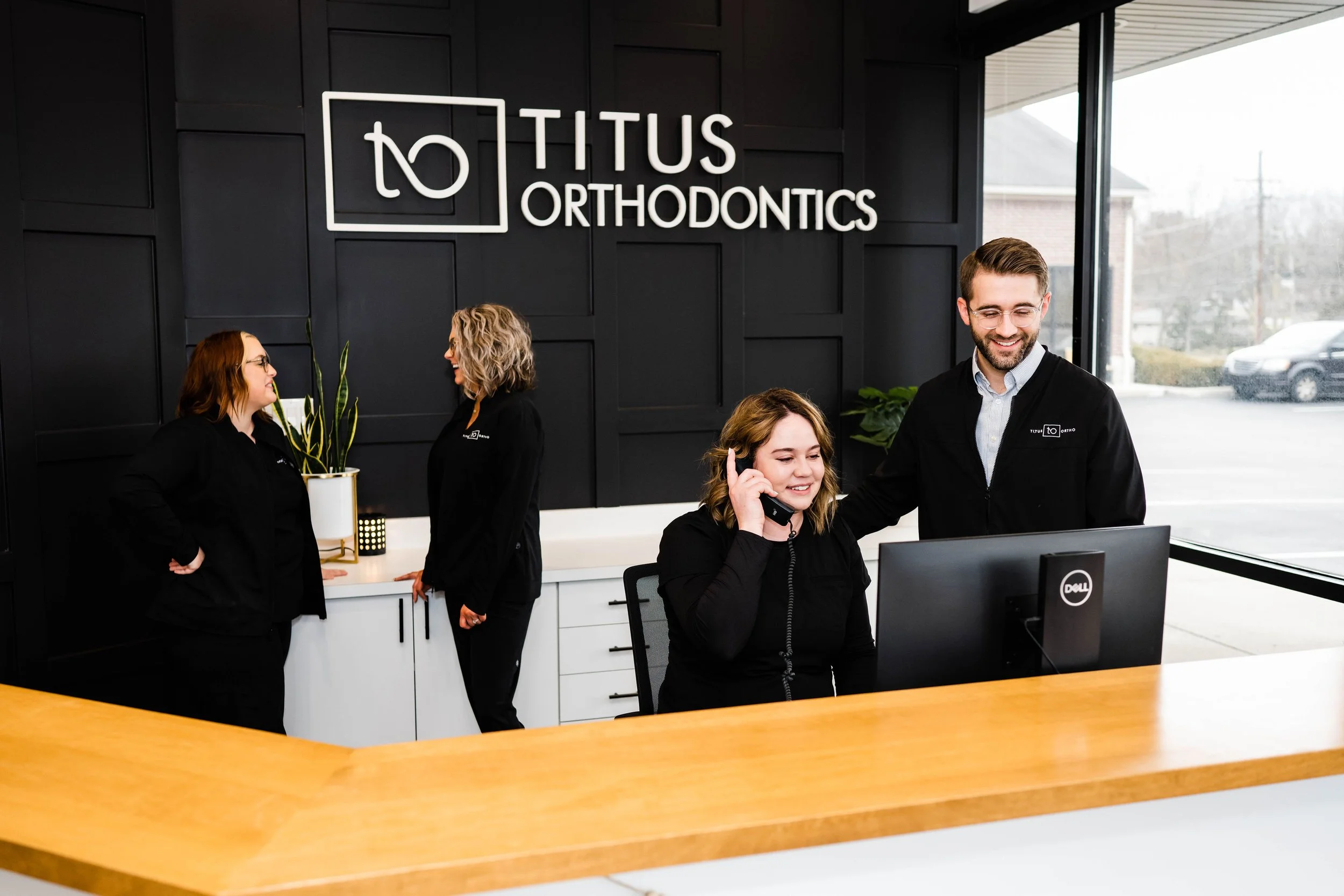 Orthodontic team consulting at the front desk in a modern clinic setting