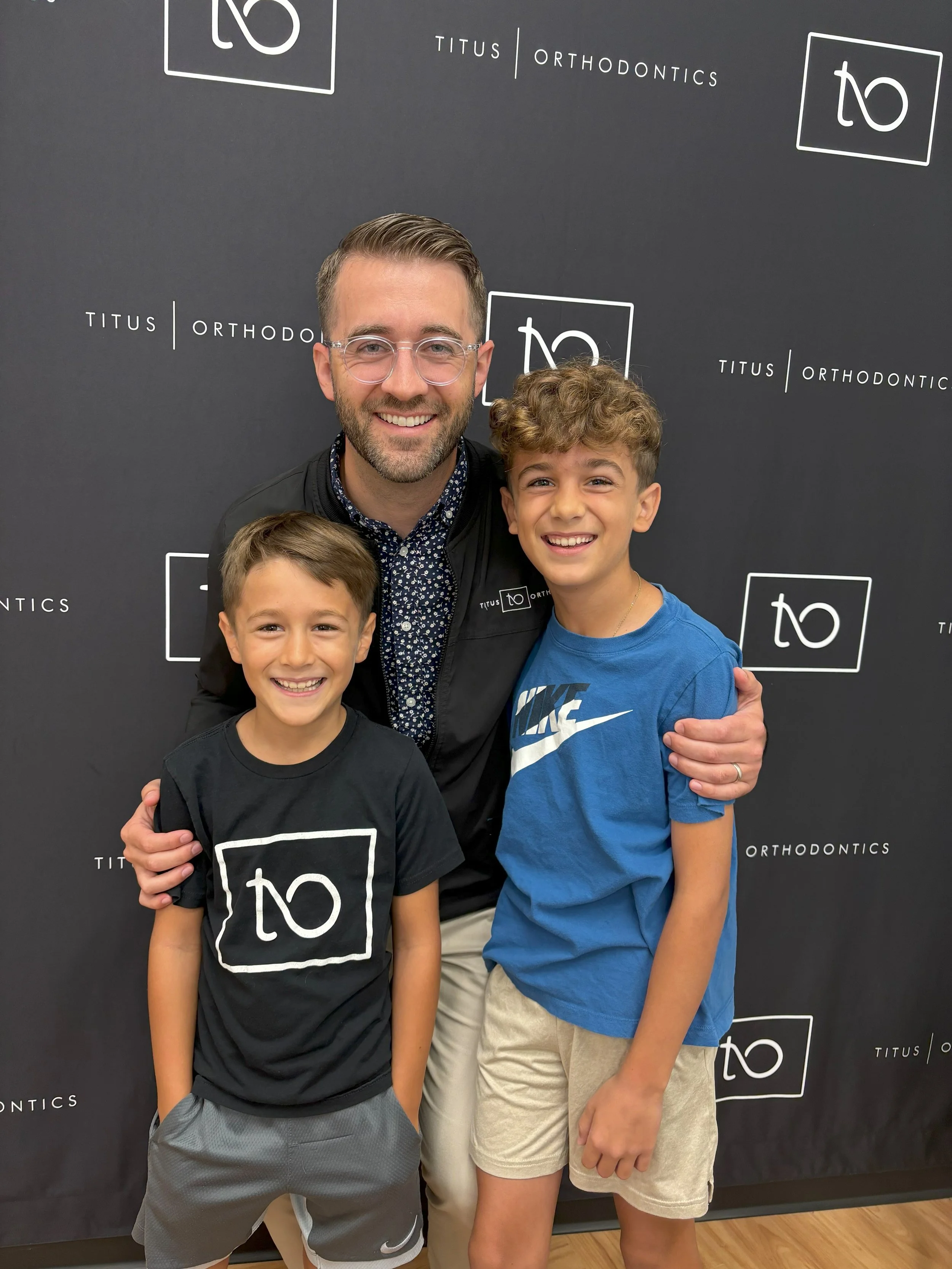 Group photo of people smiling at an orthodontic office event - How to Floss with Braces in Westfield, IN