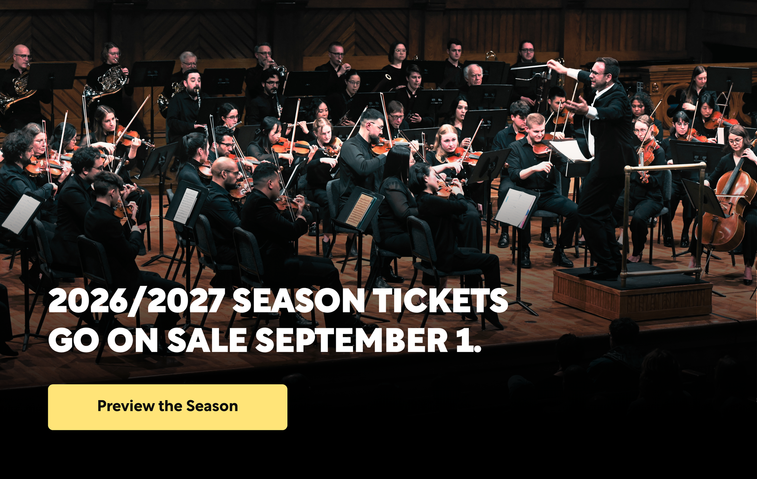 A large orchestra playing music, with a conductor waiving his baton joyfully.