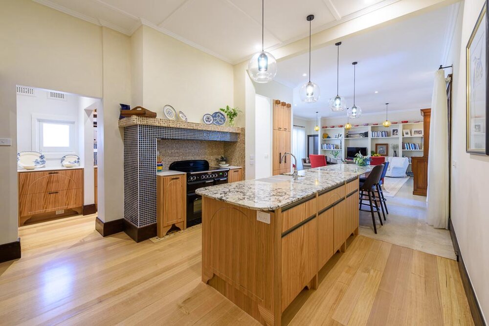 Kitchen joinery, in Tasmanian oak, reflects arch details seen in the exterior masonry and windows. Executed by Peter Gill. Hand blown glass pendants by Mark Douglass, Melbourne. Image: VSTYLE