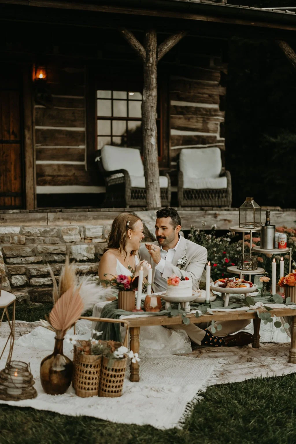 Newlyweds enjoying a styled luxury picnic reception outside a rustic cabin in Asheville North Carolina