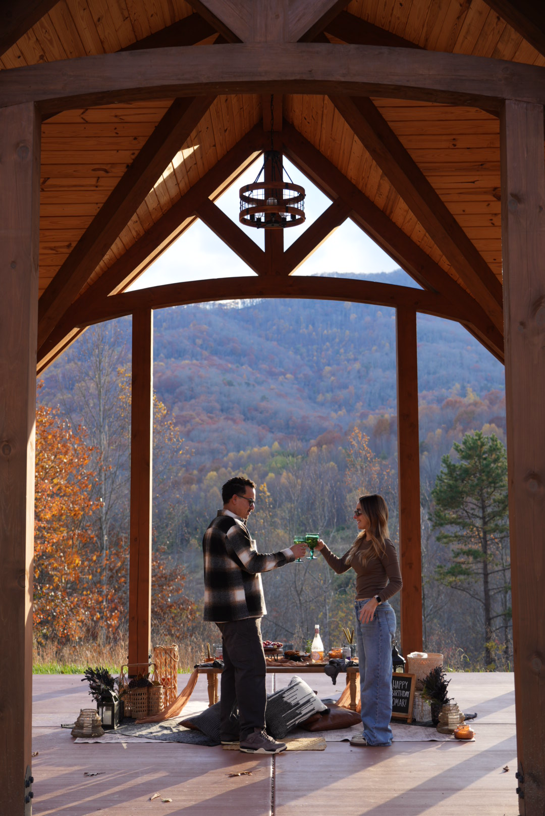 Couple toasting drinks during a romantic luxury picnic under a mountain pavilion in Asheville North Carolina