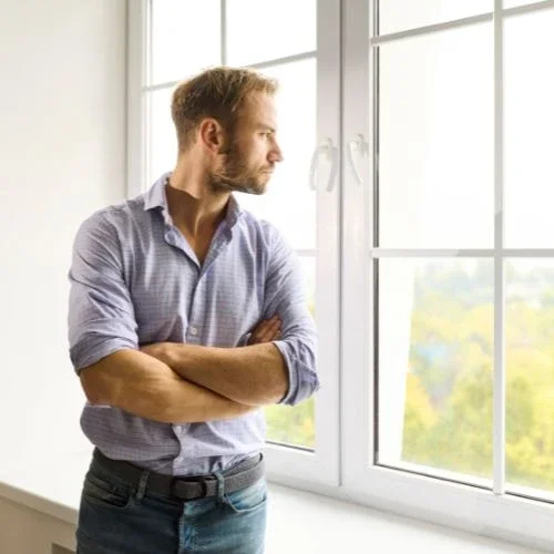 Thoughtful man by a window on the stress therapy page