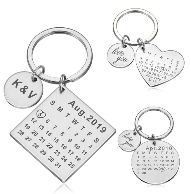Conjunto de chaves personalizadas com calendário de datas especiais, incluindo nomes, datas de aniversários e frases românticas em latas de metal.