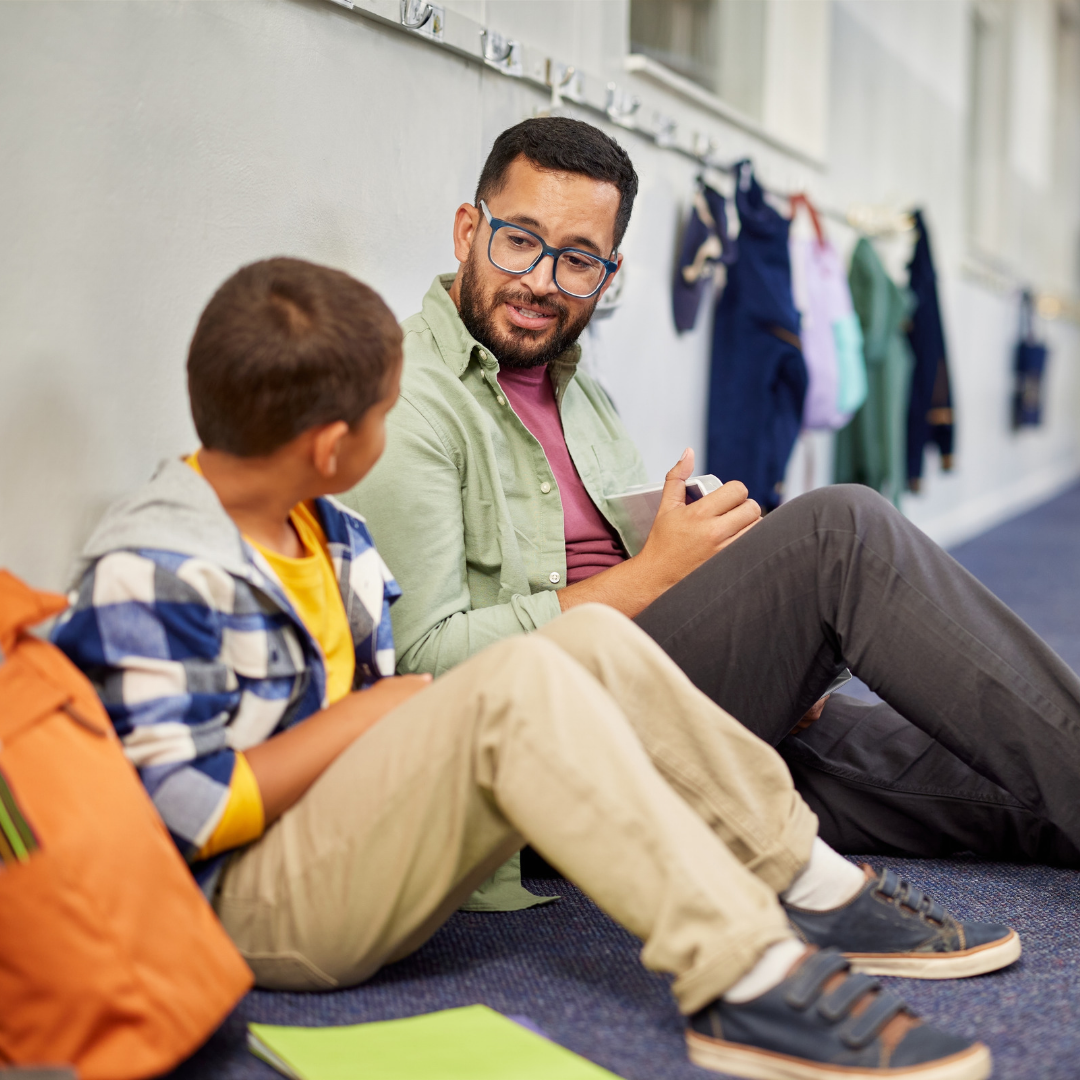 Social worker sitting with a young person, listening