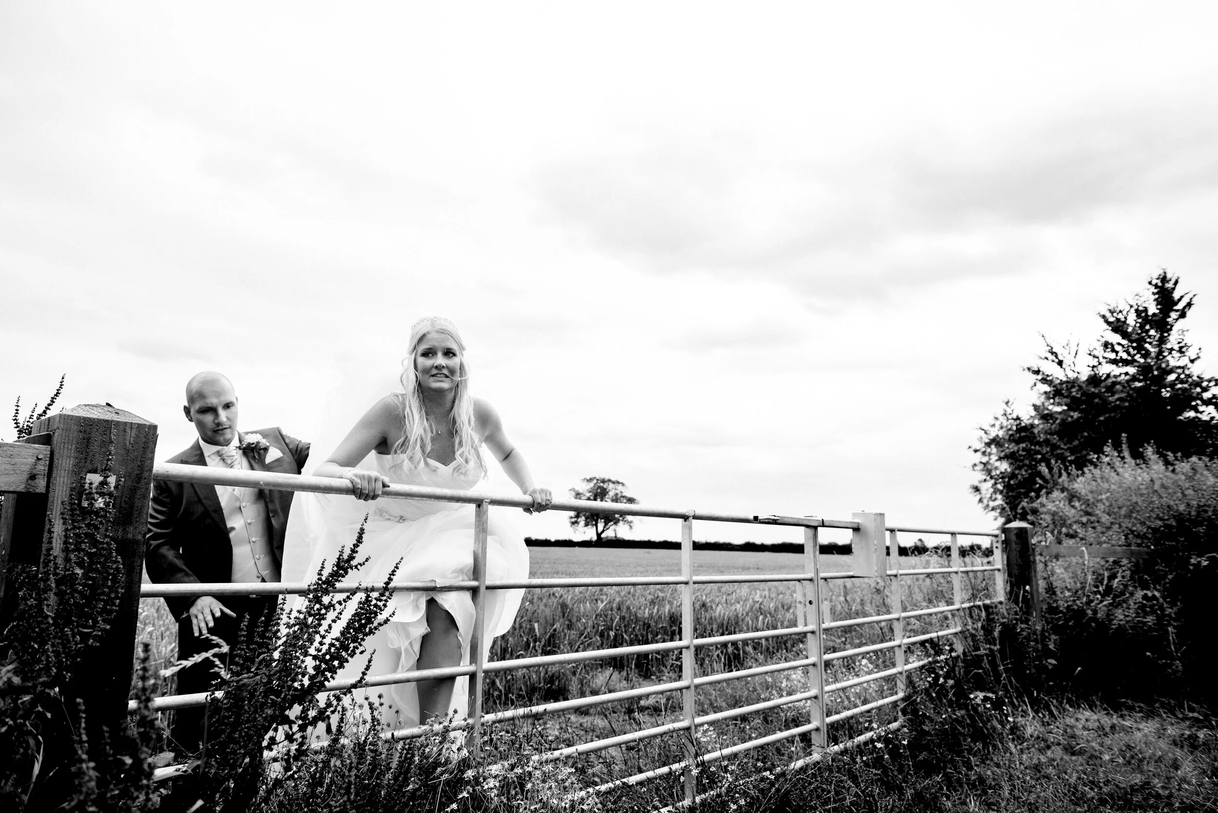 bride climbing fence, bride and groom portraits in a filed, York wedding