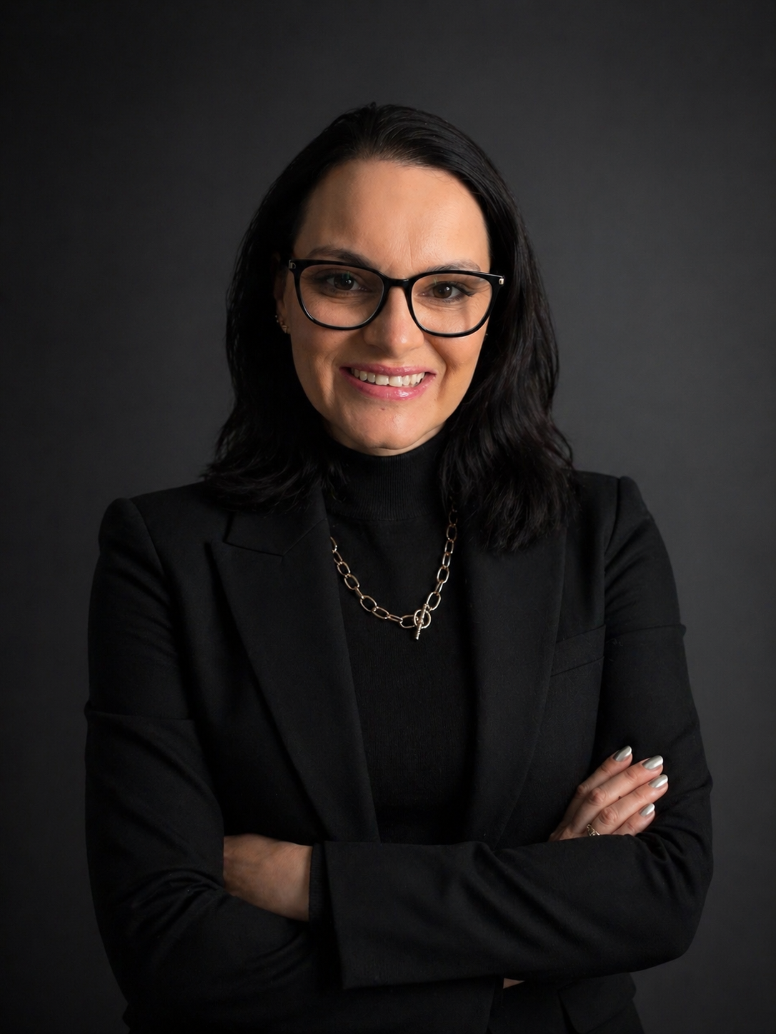 Headshot of a woman with black hair and wearing glasses