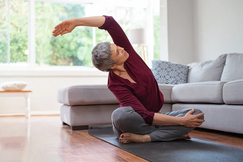 grey hair woman seated side stretch twist.jpg