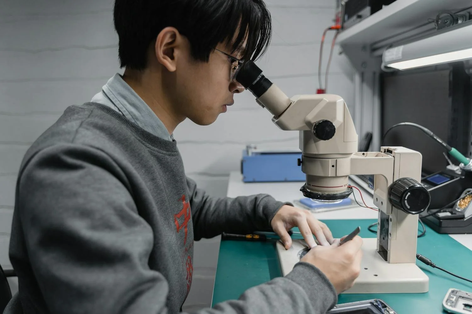 A student looking through a microscope at cells