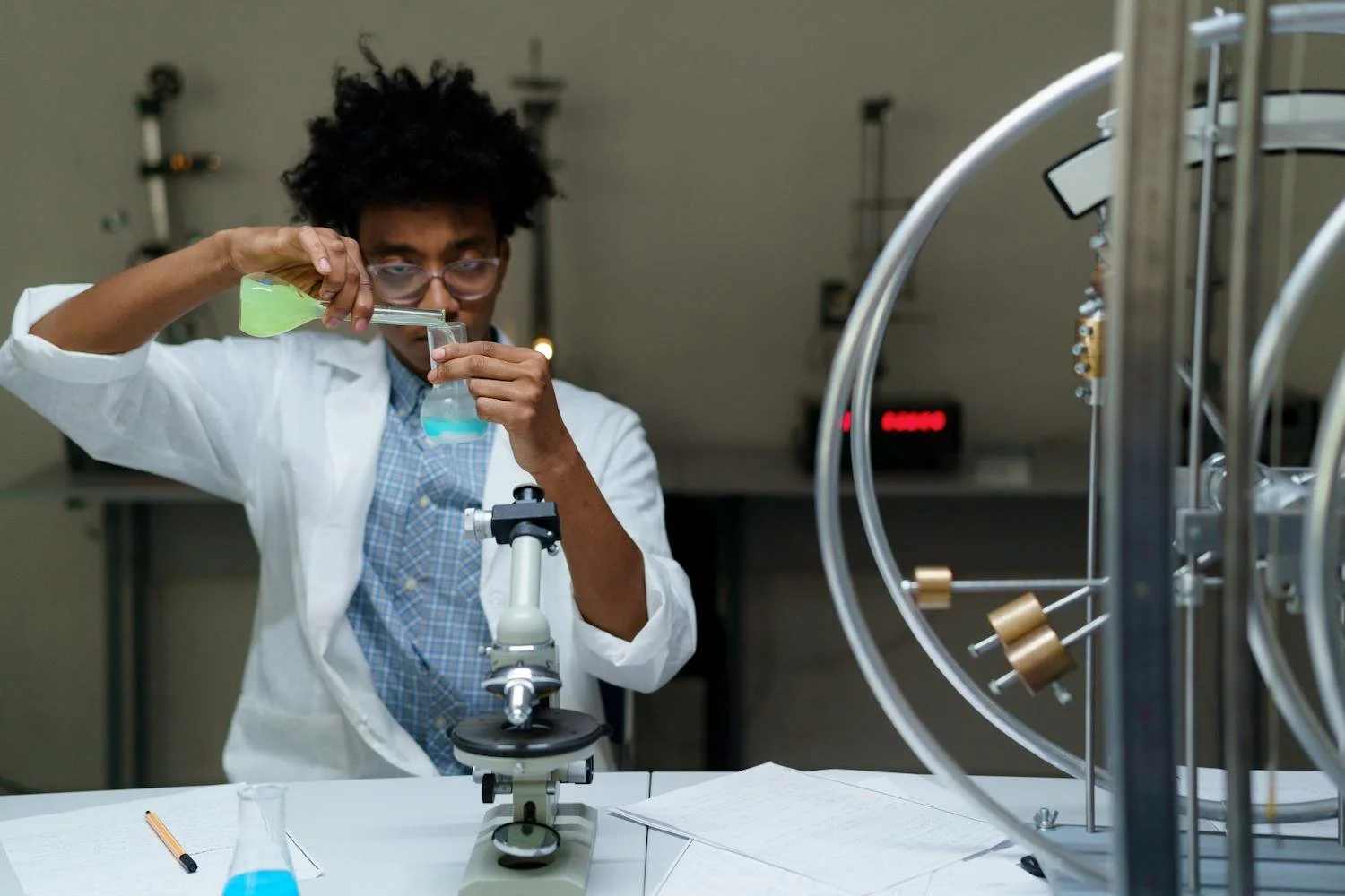 Student studying chemistry with lab equipment or periodic table
