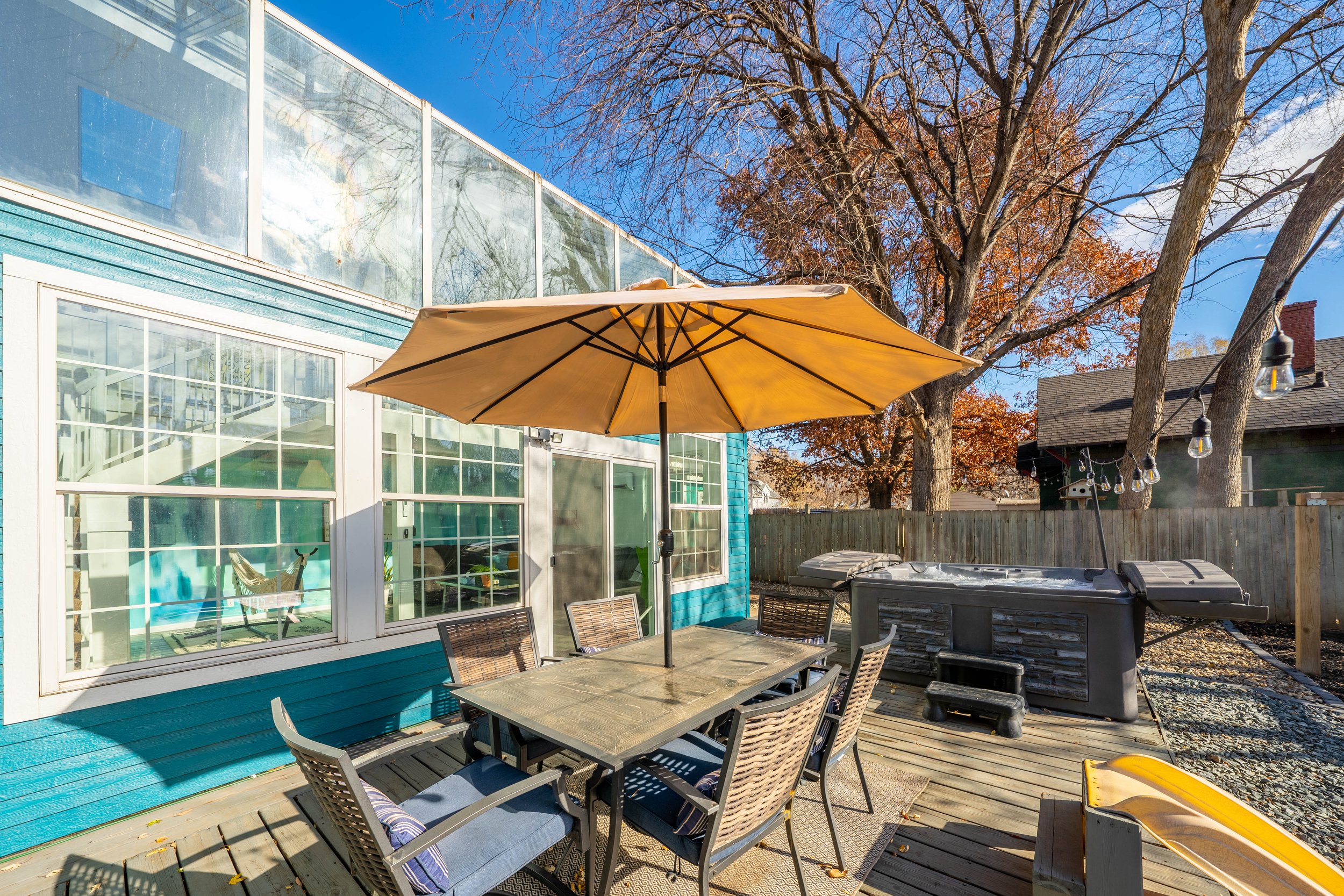 Outdoor deck with table, chairs, umbrella, and hot tub
