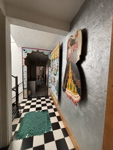 The hallway has Persian-style paintings and decorated door frames