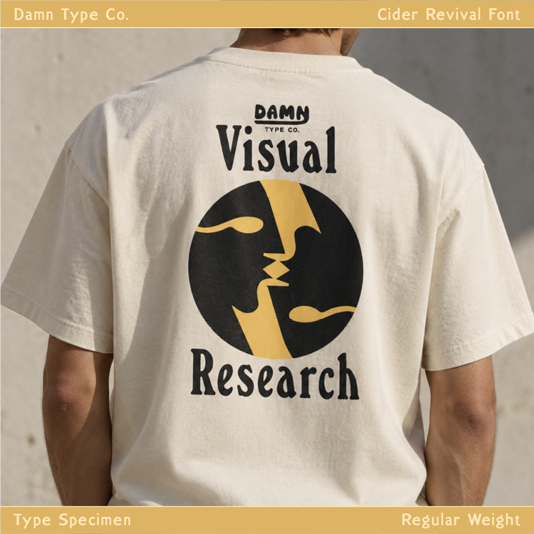Cream T-shirt featuring “Visual Research” in black Cider Revival lettering, a circular black and gold face illustration, and a small Damn Type Co. logo.