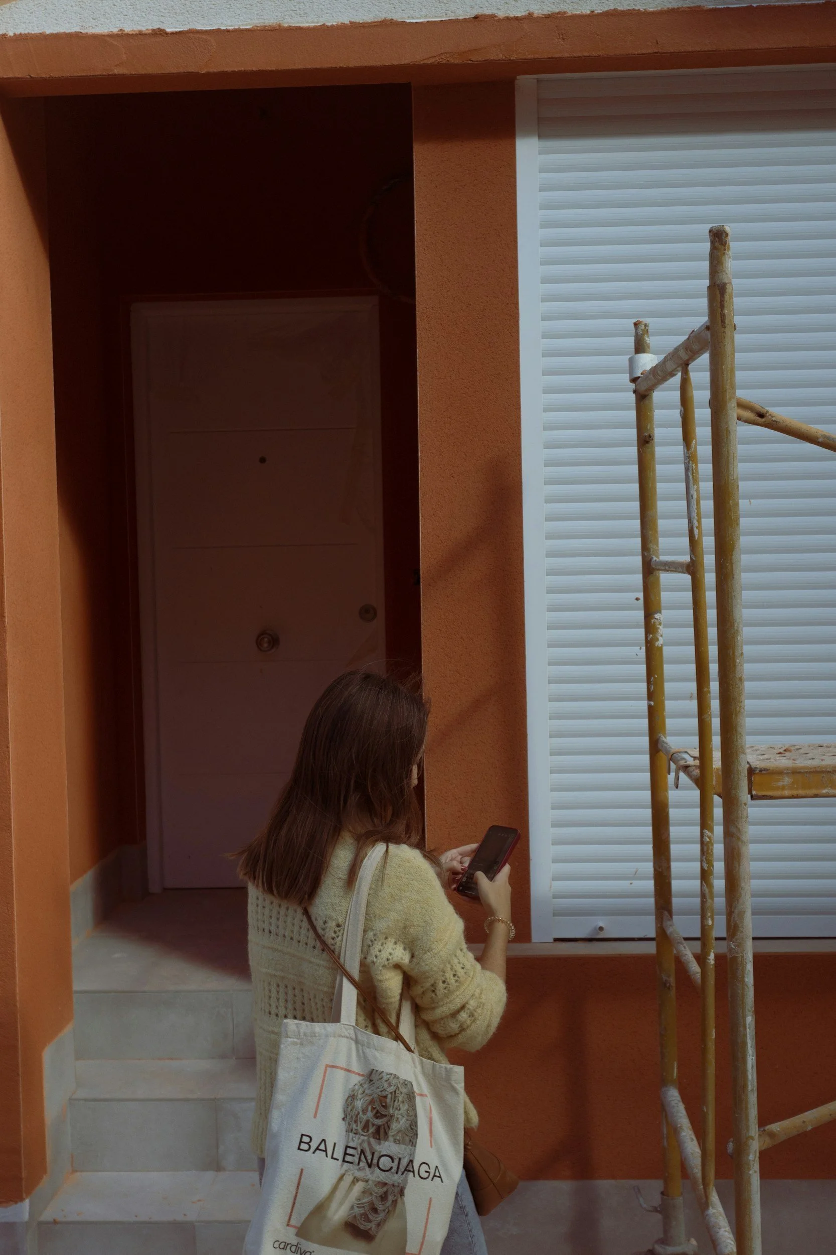Woman standing on the sidewalk texting on her cell phone. Through childhood trauma therapy in Sugar Land, TX, you can heal anxious attachment patterns rooted in inconsistent caregiving.
