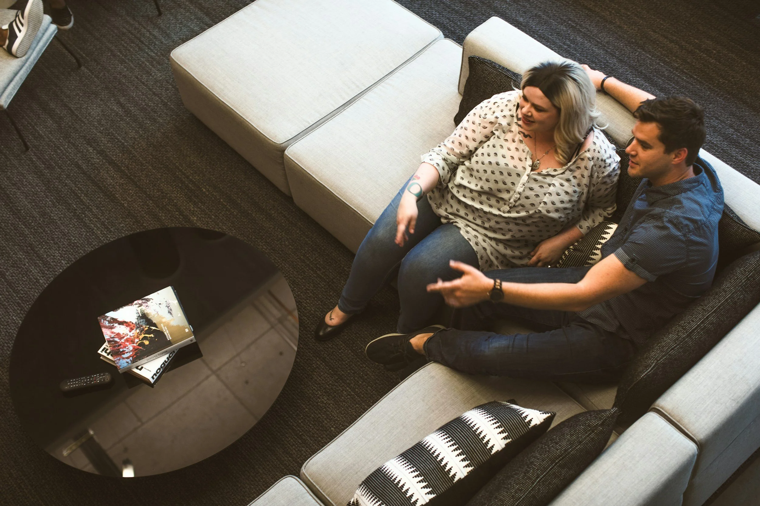 Happy couple sitting close together on a couch. When separation strains your marriage, couples therapy in Sugar Land, TX teaches you how to communicate and rebuild intimacy.