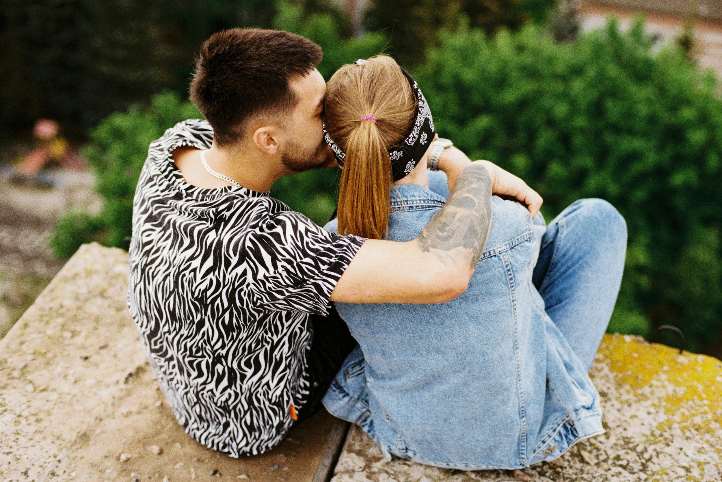 Man and woman sitting next to each other on a rock outside. Rediscover why you were best friends and strengthen your relationship with couples therapy in Sugar Land, TX.