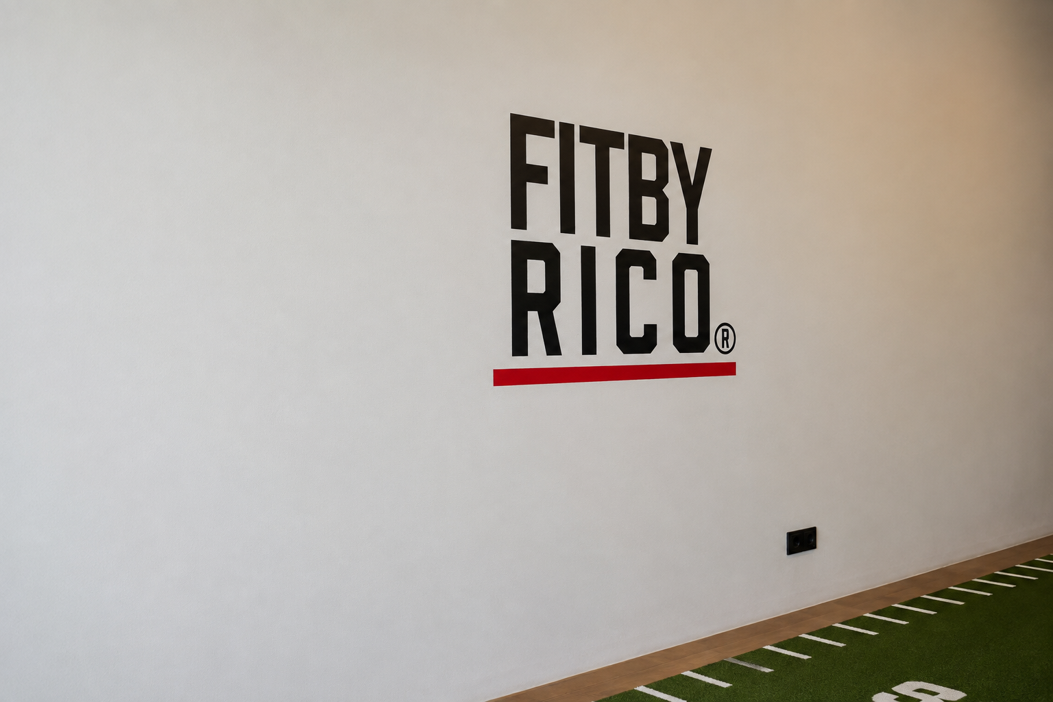 Fitby Rico logo op de muur van de personal training studio.