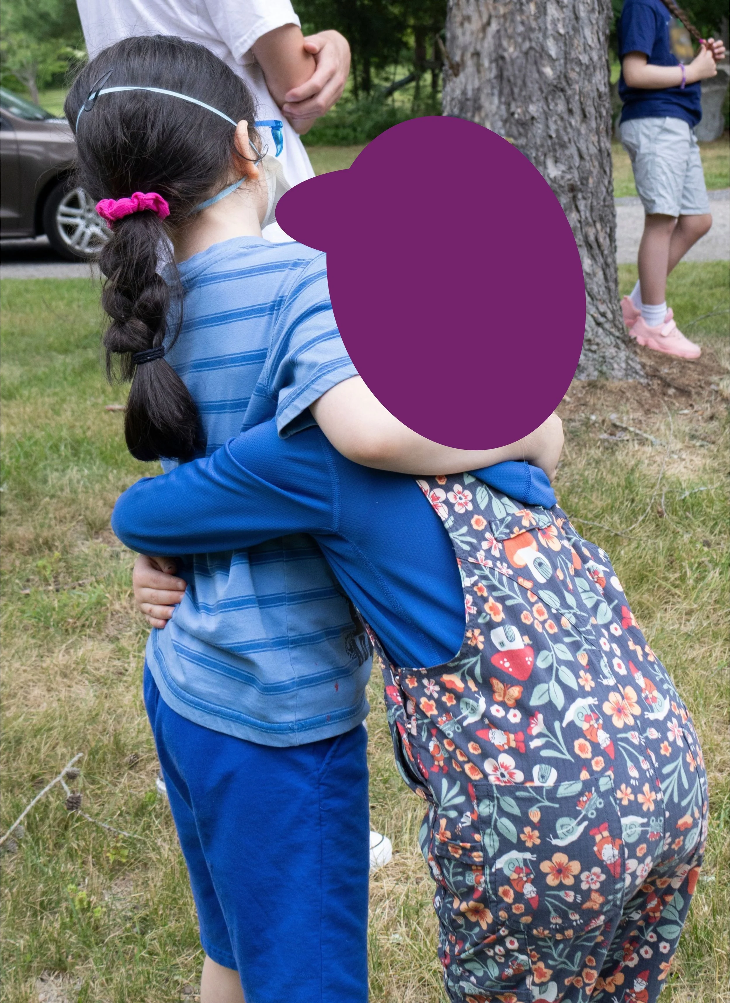 wo children hugging outdoors