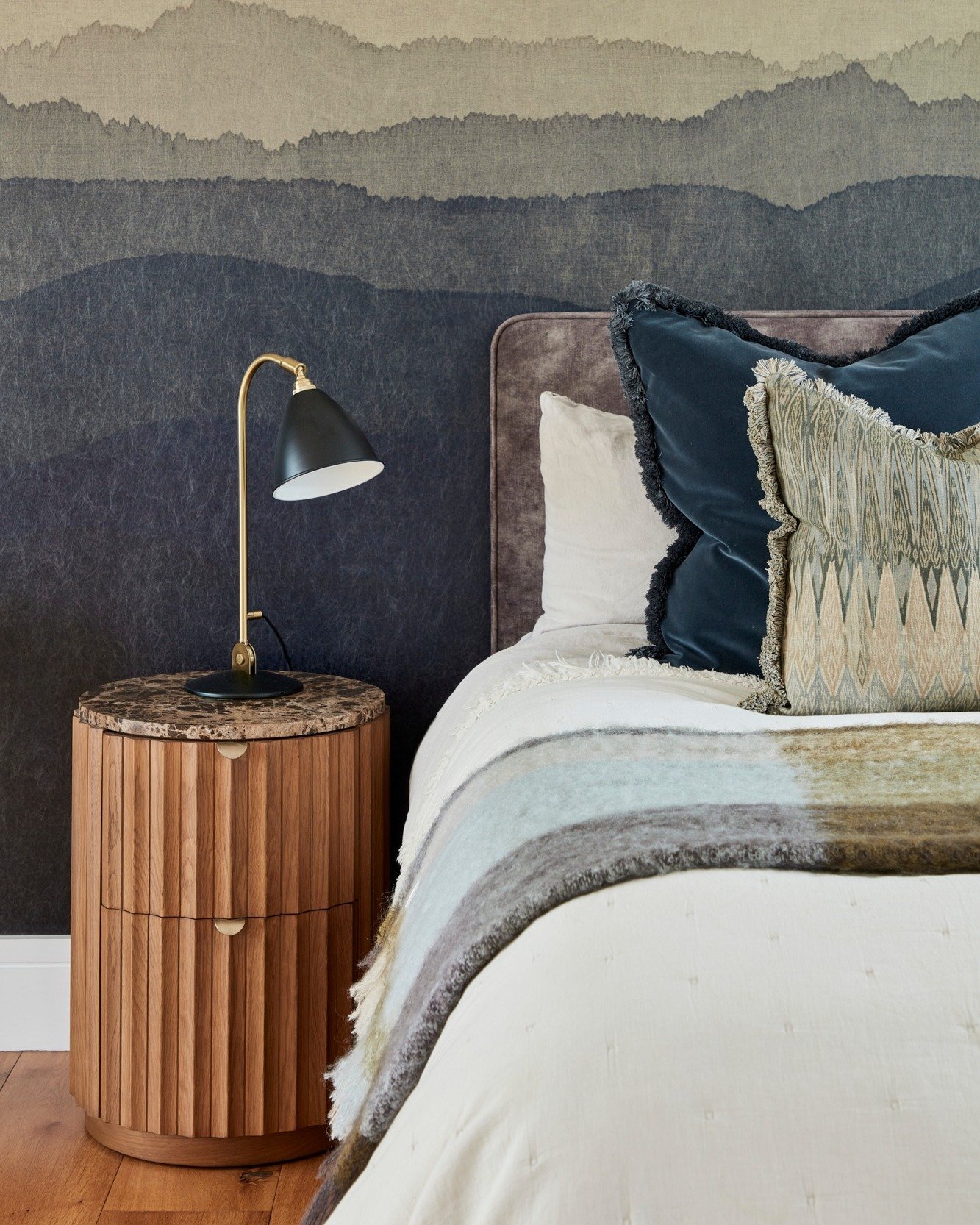 Did you know that even in the heart of London, your bedroom can feel like a tranquil retreat? 🌿 For our recent Marylebone project, we've embraced a palette of calming greys and deep blues, set against a dramatic mountain-inspired wallpaper to elonga