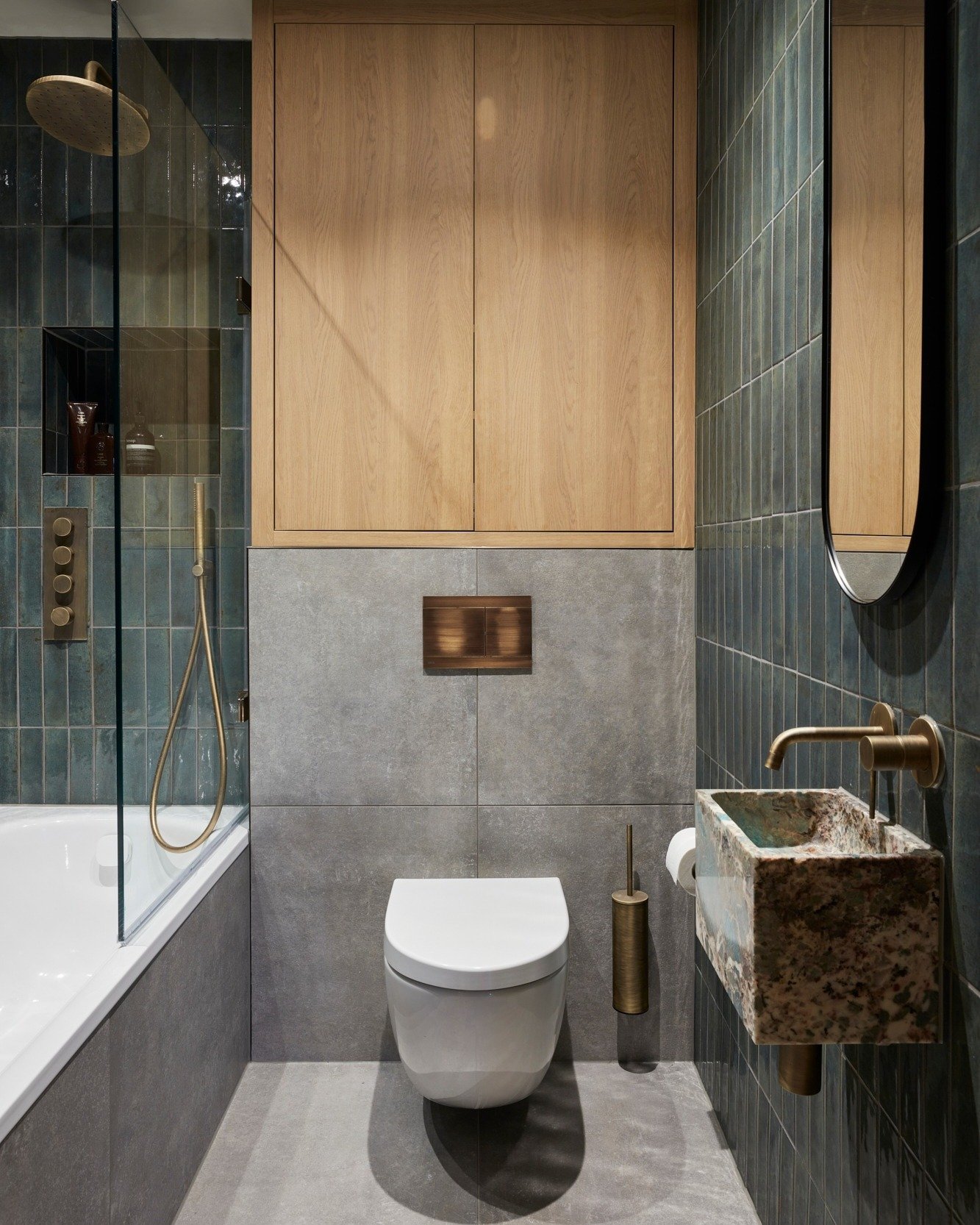 Who said compact spaces can&rsquo;t make a big statement? 

This bathroom is all about blending form and function with luxe details. We used a calming mix of textured tiles and warm wood accents to create a spa-like feel, while brass fixtures add tha